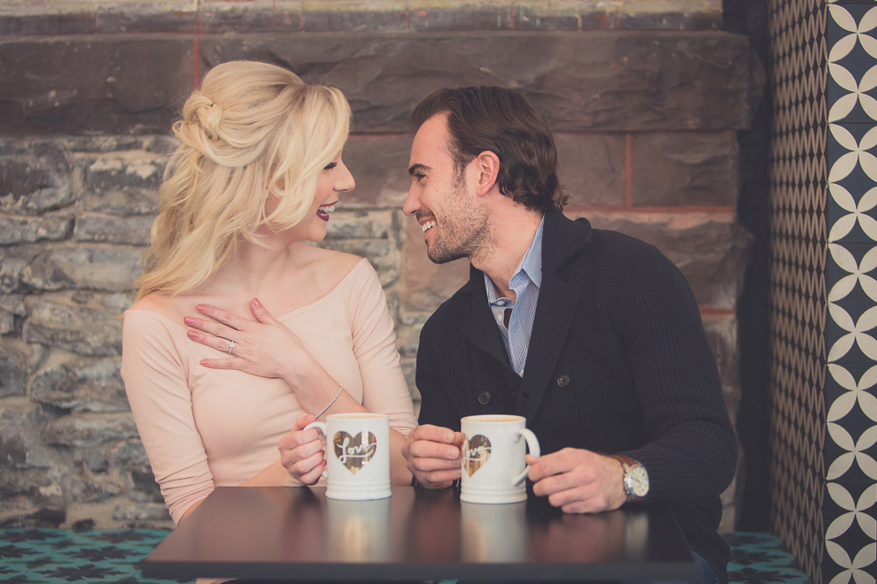 wedding engagement photography of couple looking at each other inside of coffee shop, Tipico Coffee, in Buffalo, NY