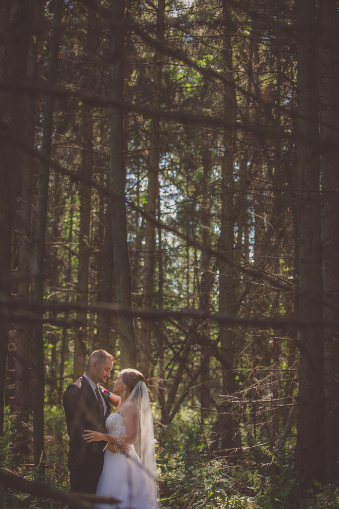 bride and groom gaze at each other in forest of Amherst State Park near Buffalo, NY on their wedding day