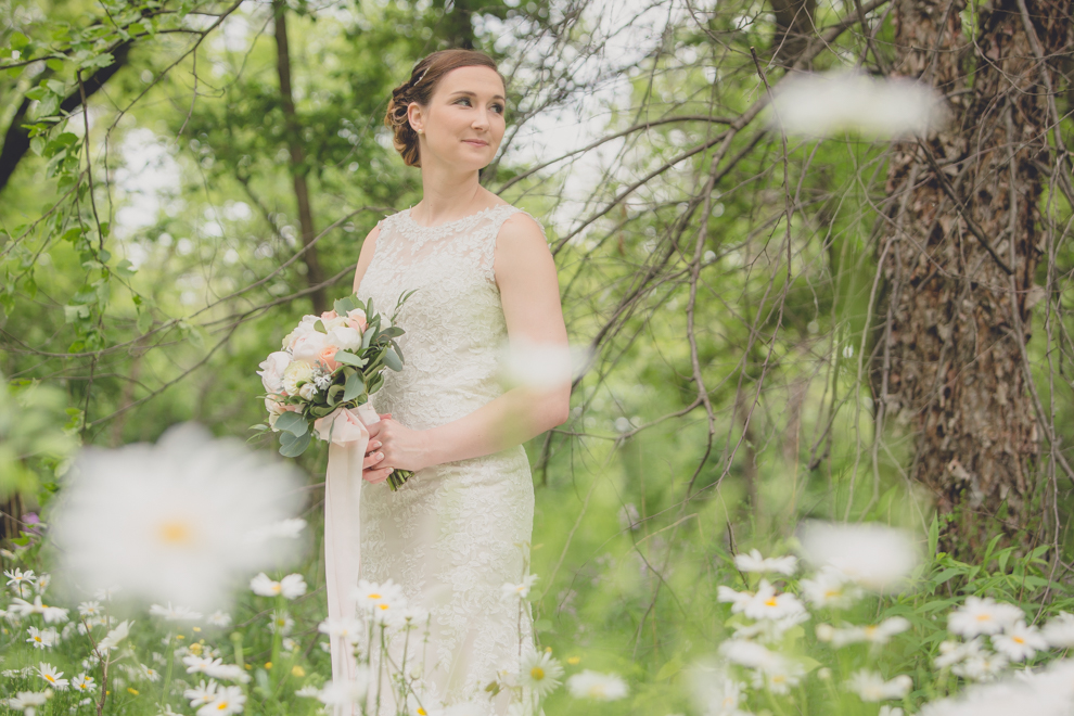 Photography of bride standing in daisy field at Burchfield Nature Center in Buffalo, NY on her wedding day