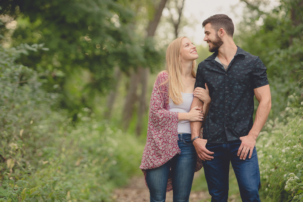 engagement photography of bride and groom looking at each other in forest at Tifft Nature Preserve in Buffalo, NY