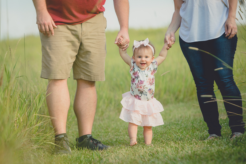 mom and dad hold baby