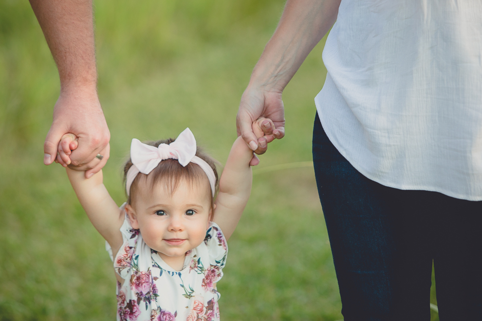 mom and dad hold baby