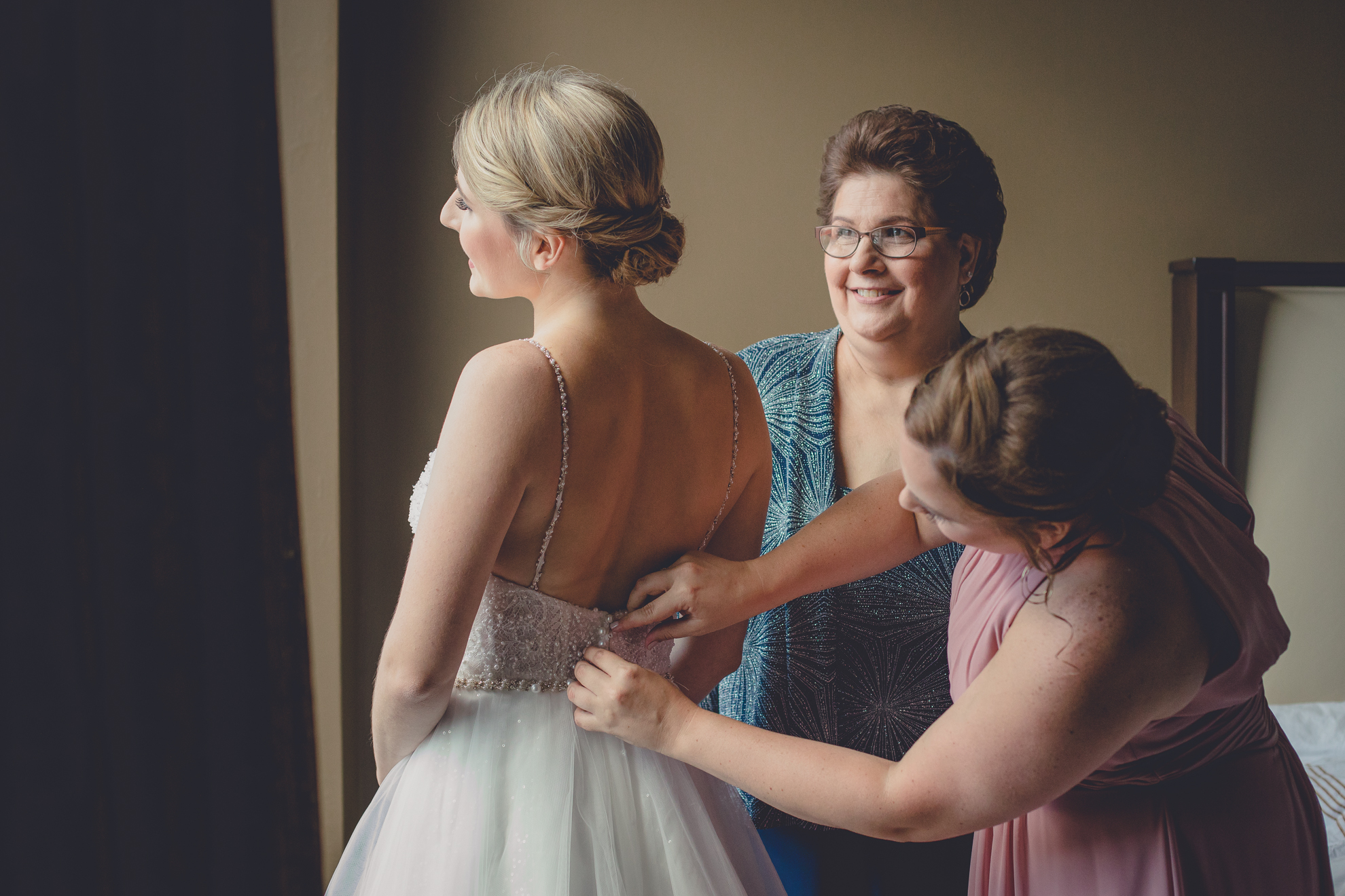 Mother looks at bride getting ready for wedding at the Curtiss Hotel in downtown Buffalo, NY