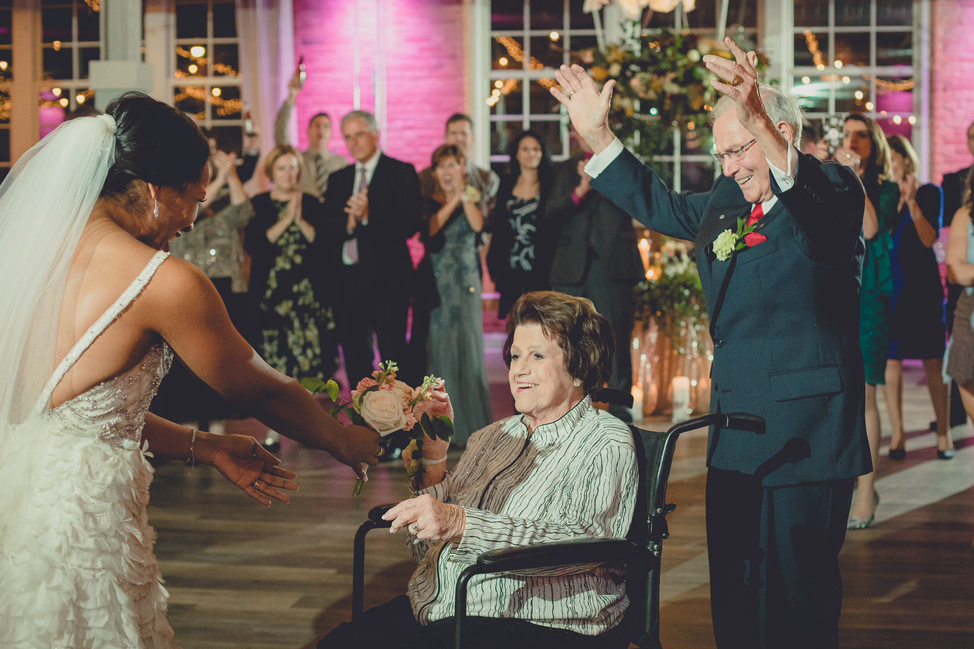 Grandmother receives bouquet from bride after winning anniversary dance at wedding reception at the Foundry Suites in downtown Buffalo, NY