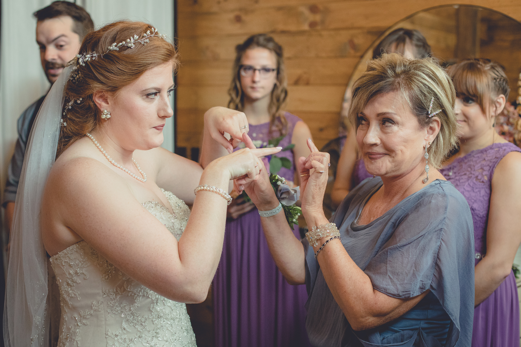 Bride and Mom gesture at each other before wedding ceremony at Hayloft in the Grove near Buffalo, NY