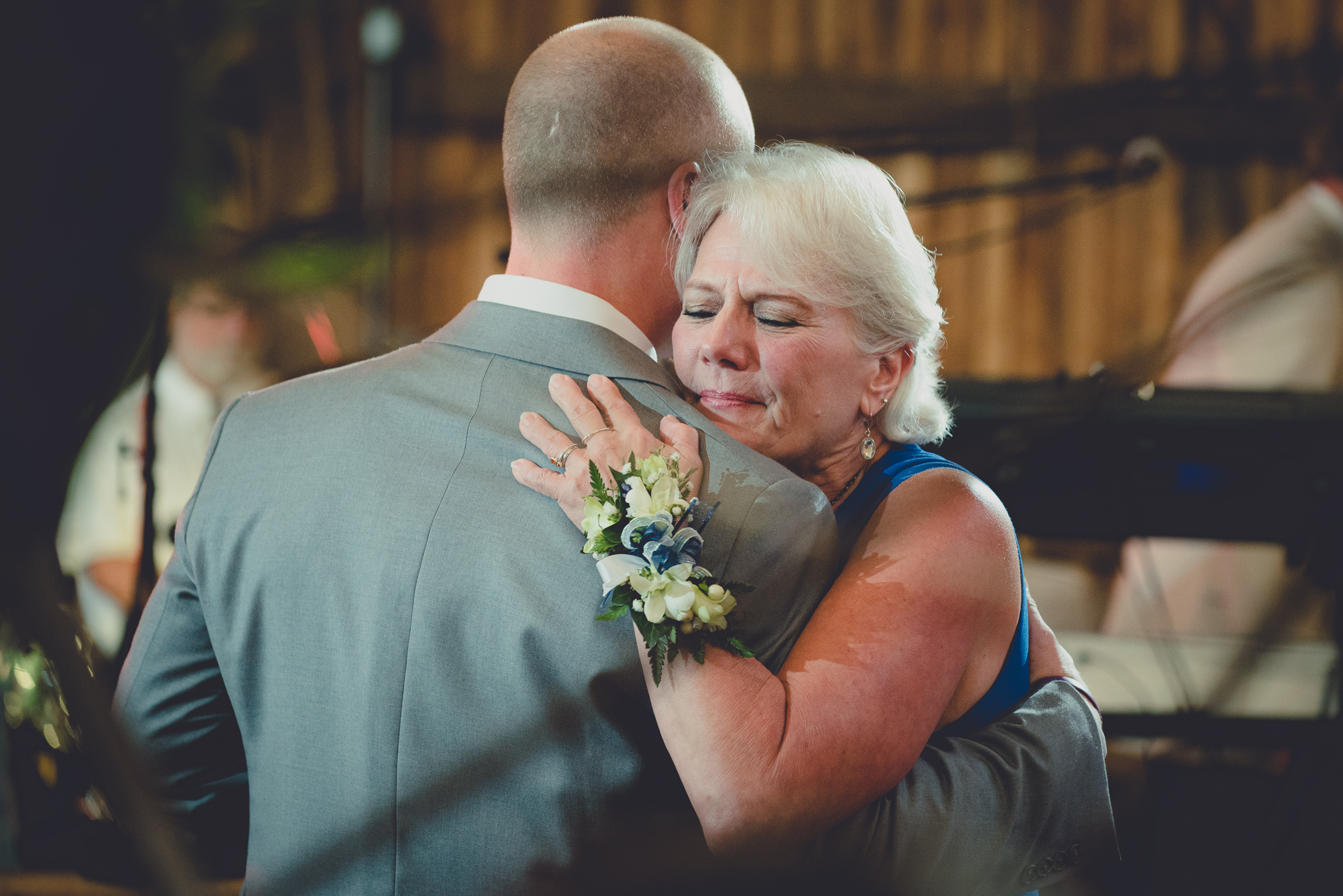 Mom cries while hugging groom during first dance at wedding reception at Hayloft in the Grove in Buffalo, NY
