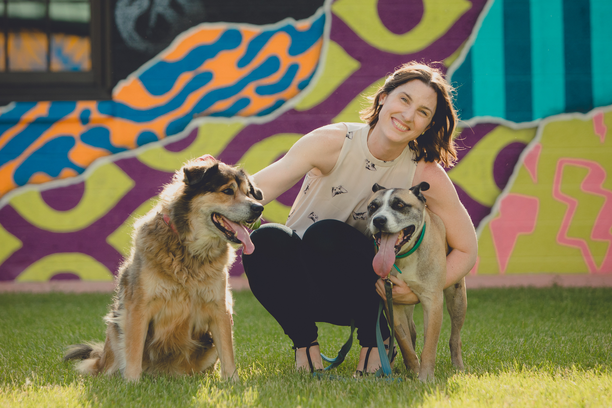 mom pets dogs in front of murals by Thin Man Chandler St. in Buffalo, NY 