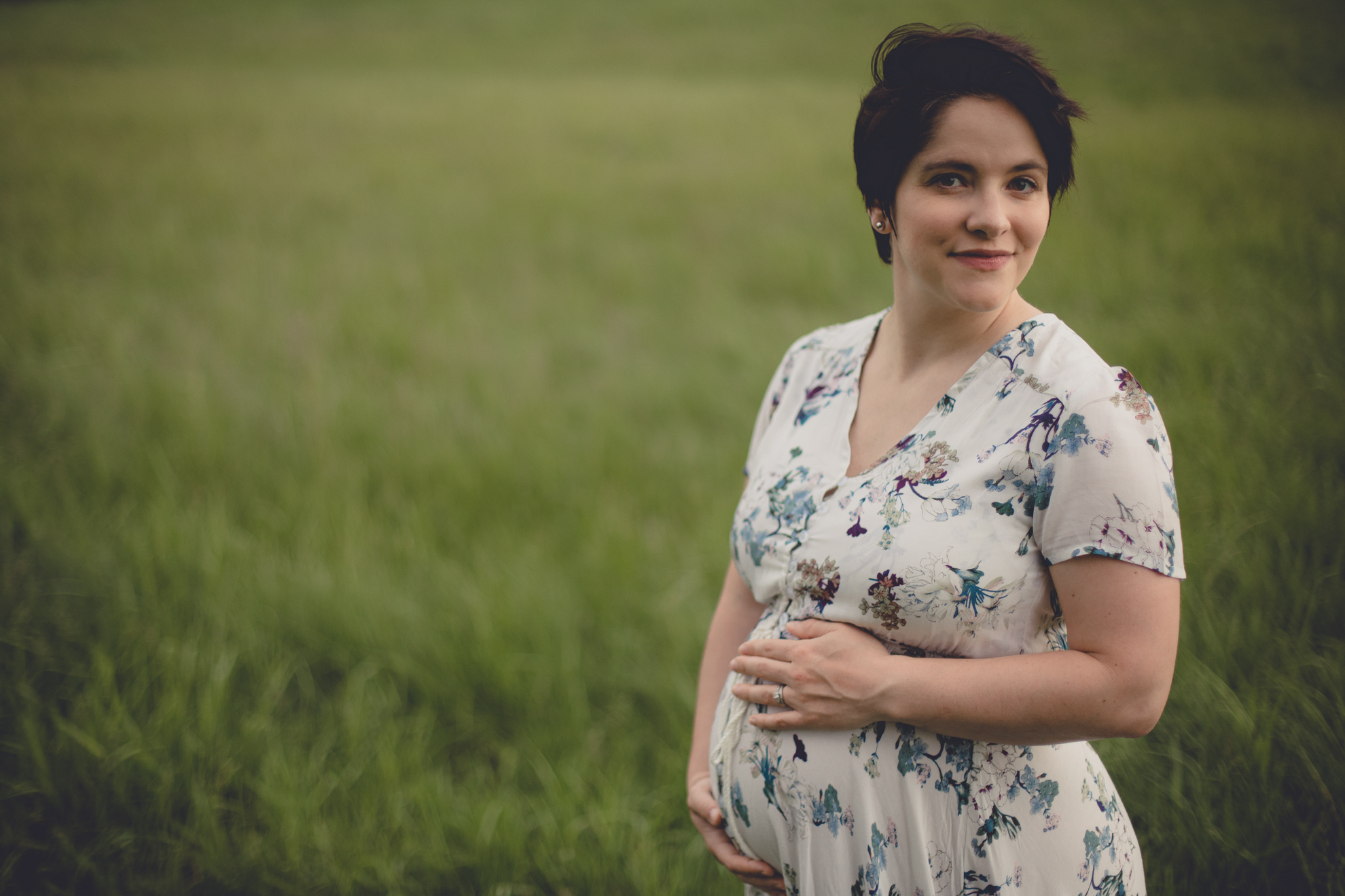 mom poses for photographer in  maternity portrait in field at Tifft Nature Preserve in Buffalo, NY