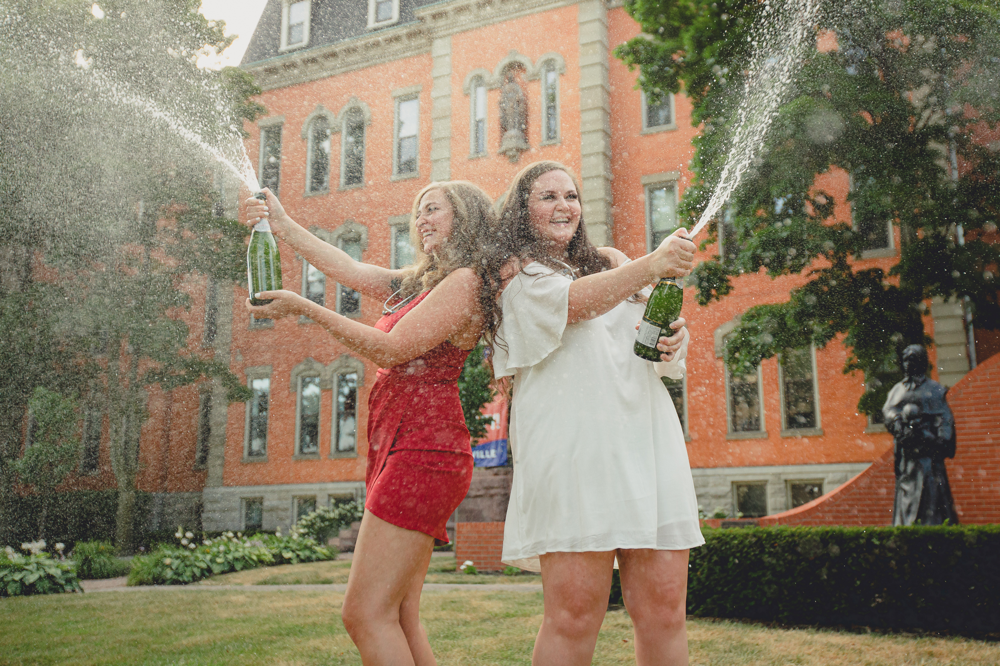 D'youville nursing students pop and spray champagne during senior graduation portrait photography session in Buffalo, NY