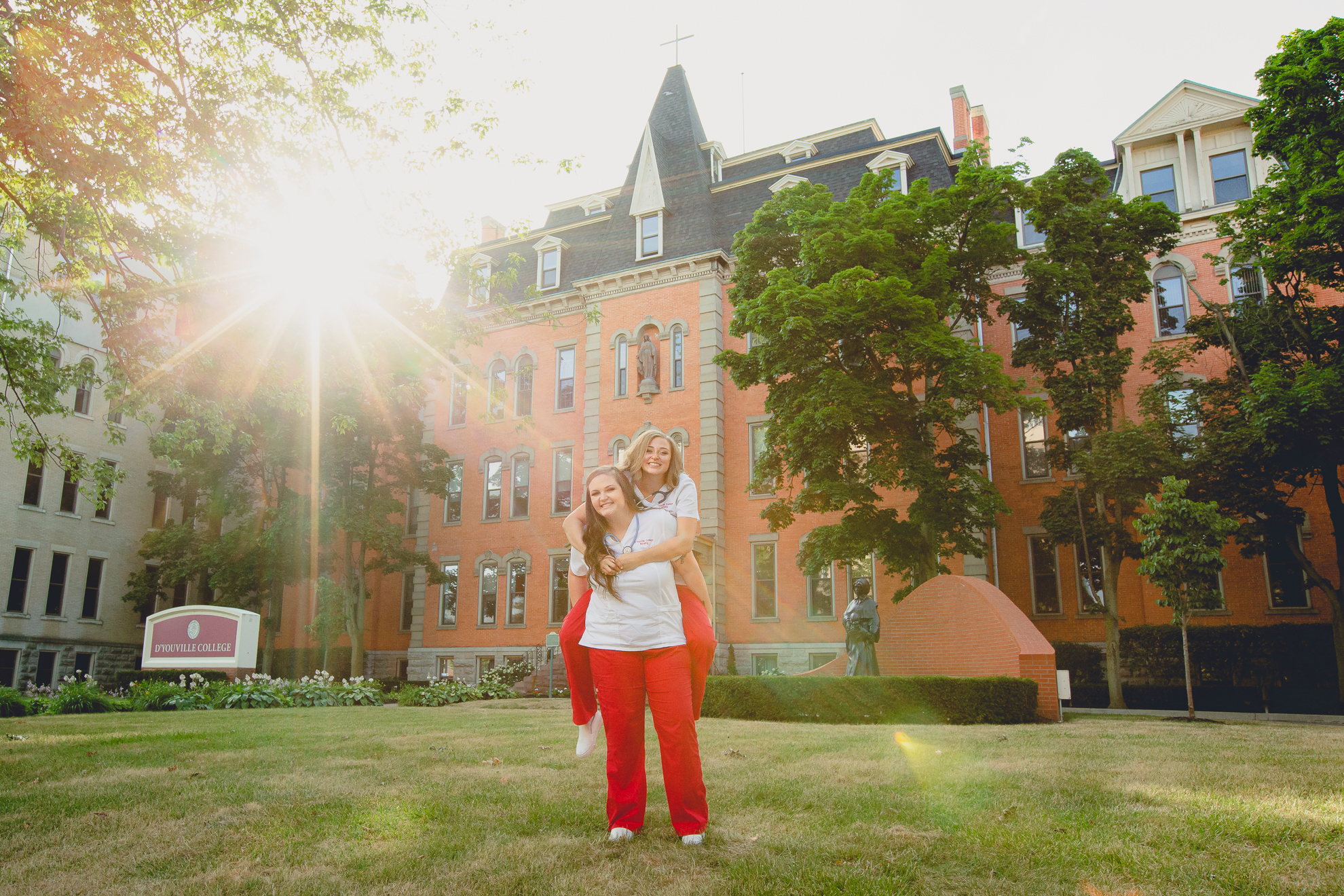 D'youville nursing students give piggy back rides on campus during senior graduation portrait photography session in Buffalo, NY