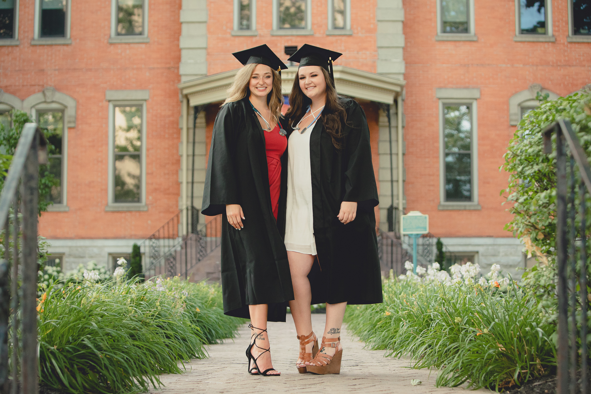 D'youville nursing students smile for photographer in caps and gowns during senior graduation portrait photography session in Buffalo, NY