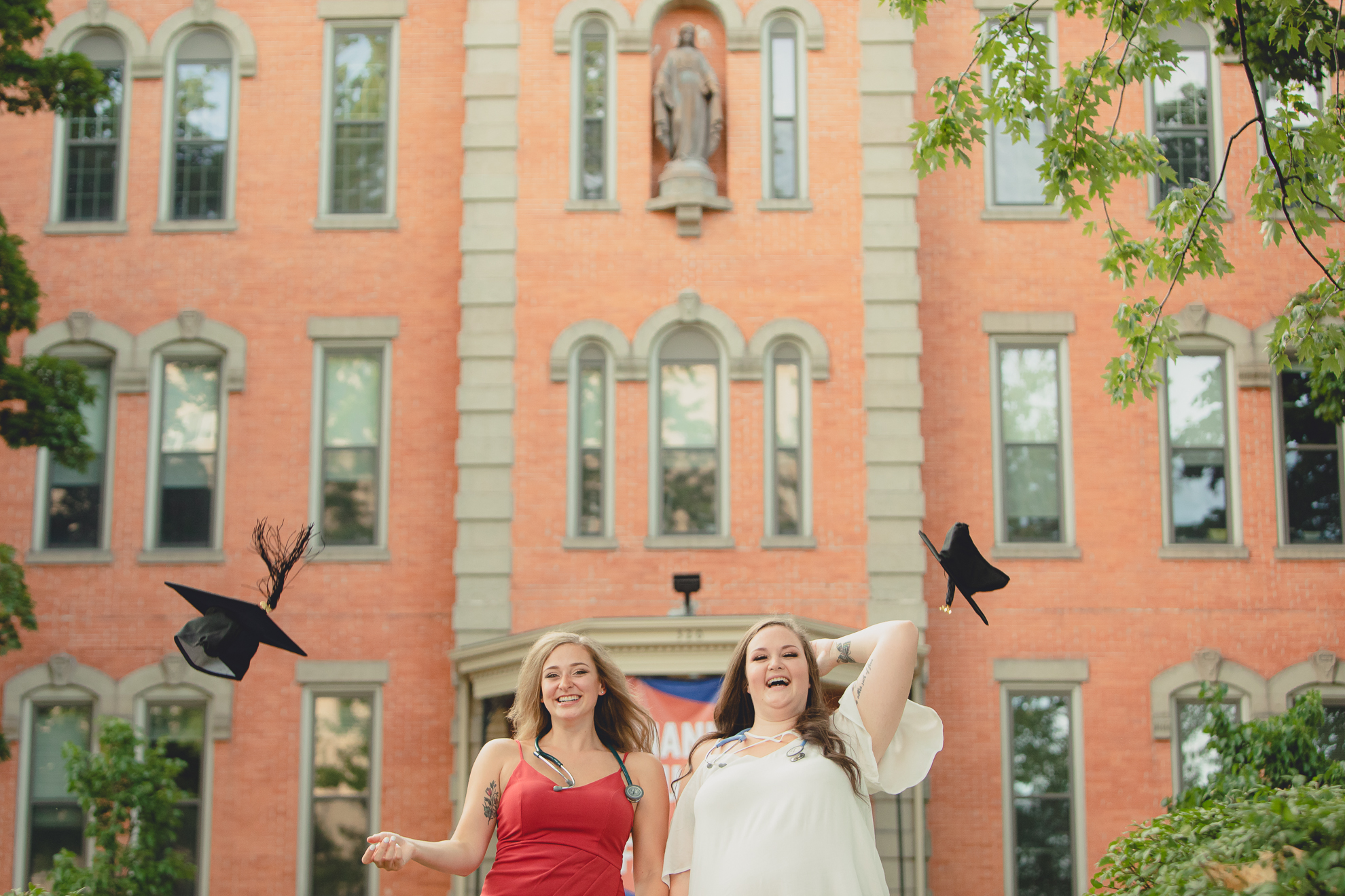 D'youville nursing students throw caps in air during senior graduation portrait photography session in Buffalo, NY