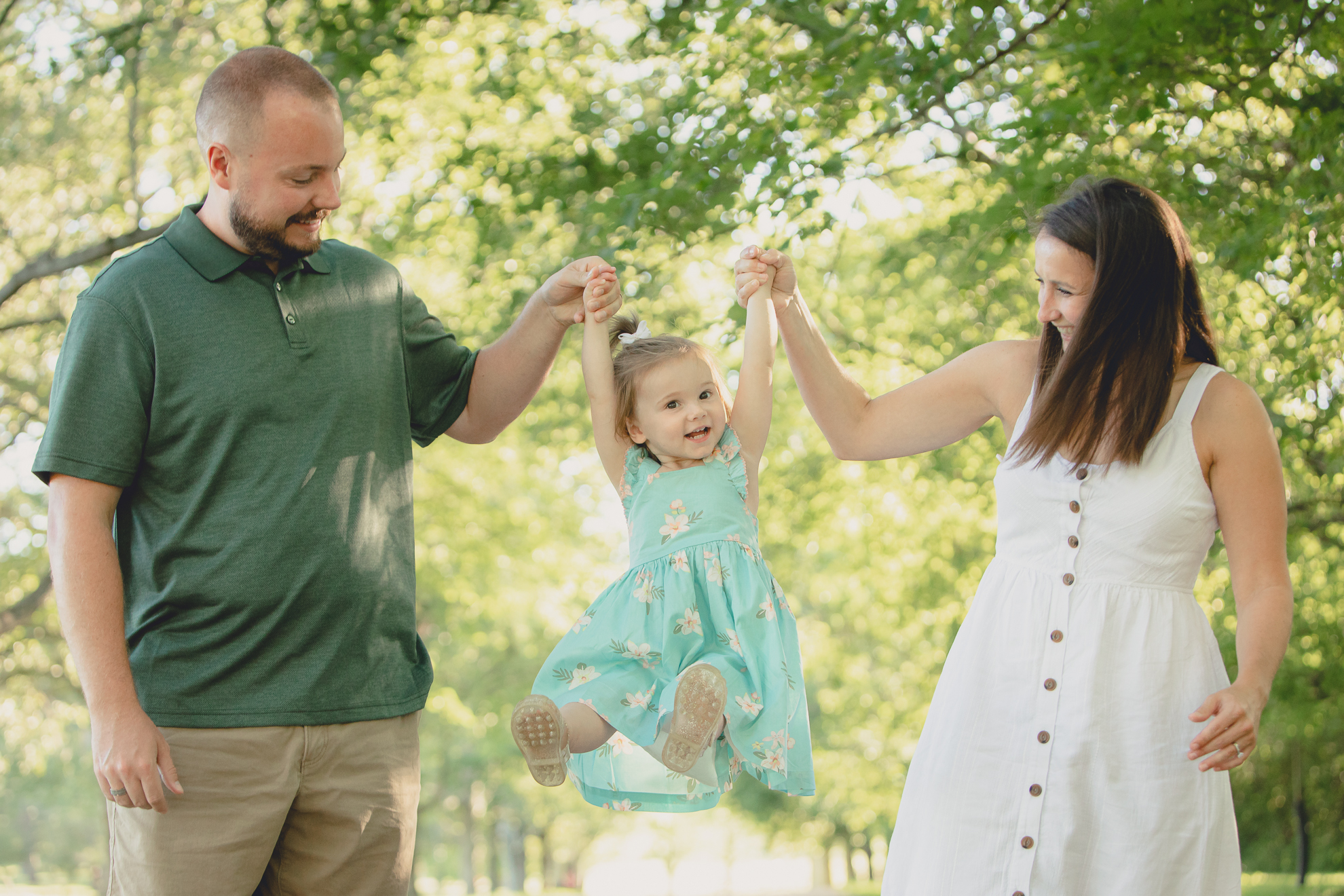 mom and dad swing child during family portrait photography session at Knox Farm in East Aurora, a small town near Buffalo