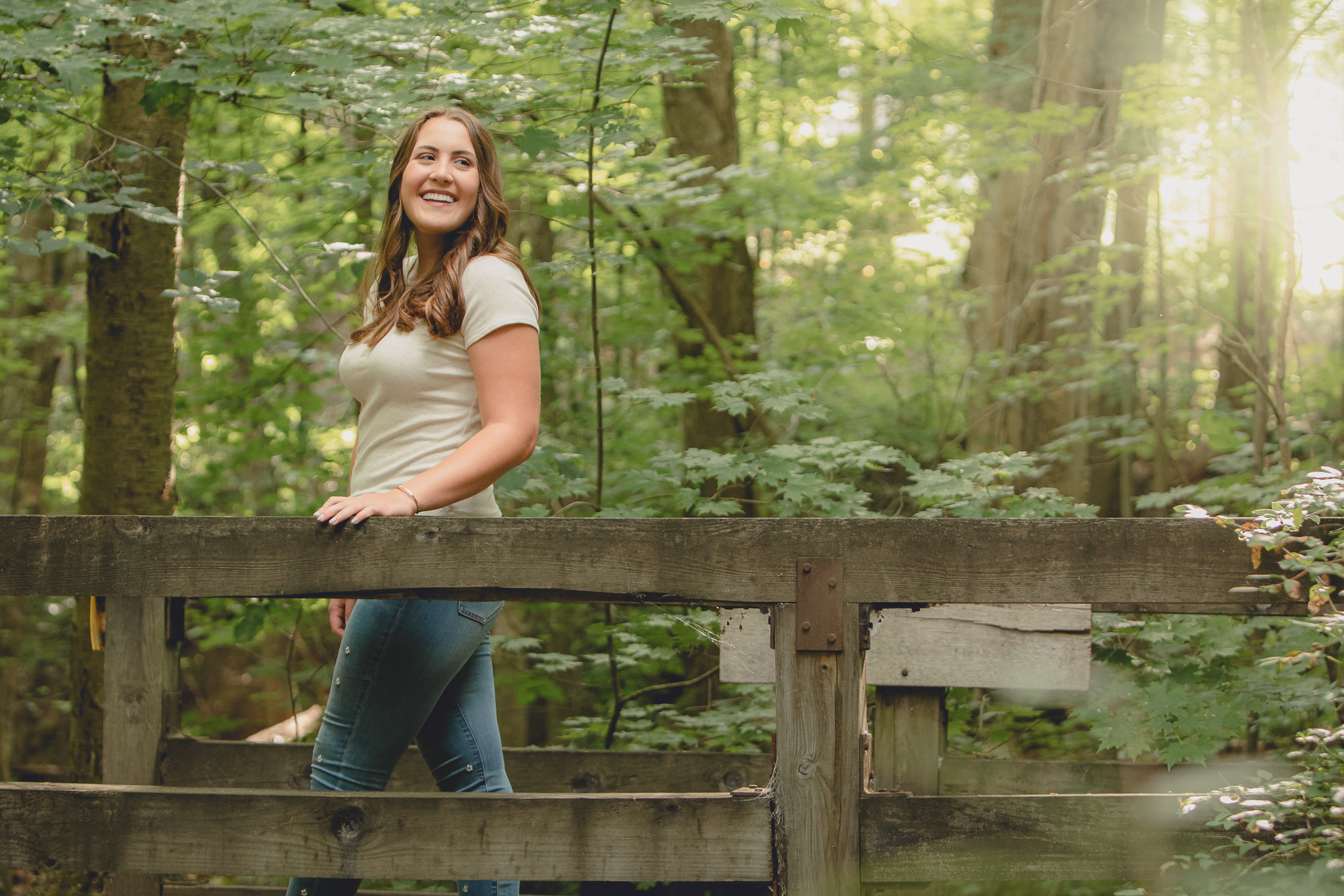 Tessa laughs on bridge during senior portrait photography session in Long Point State Park in WNY