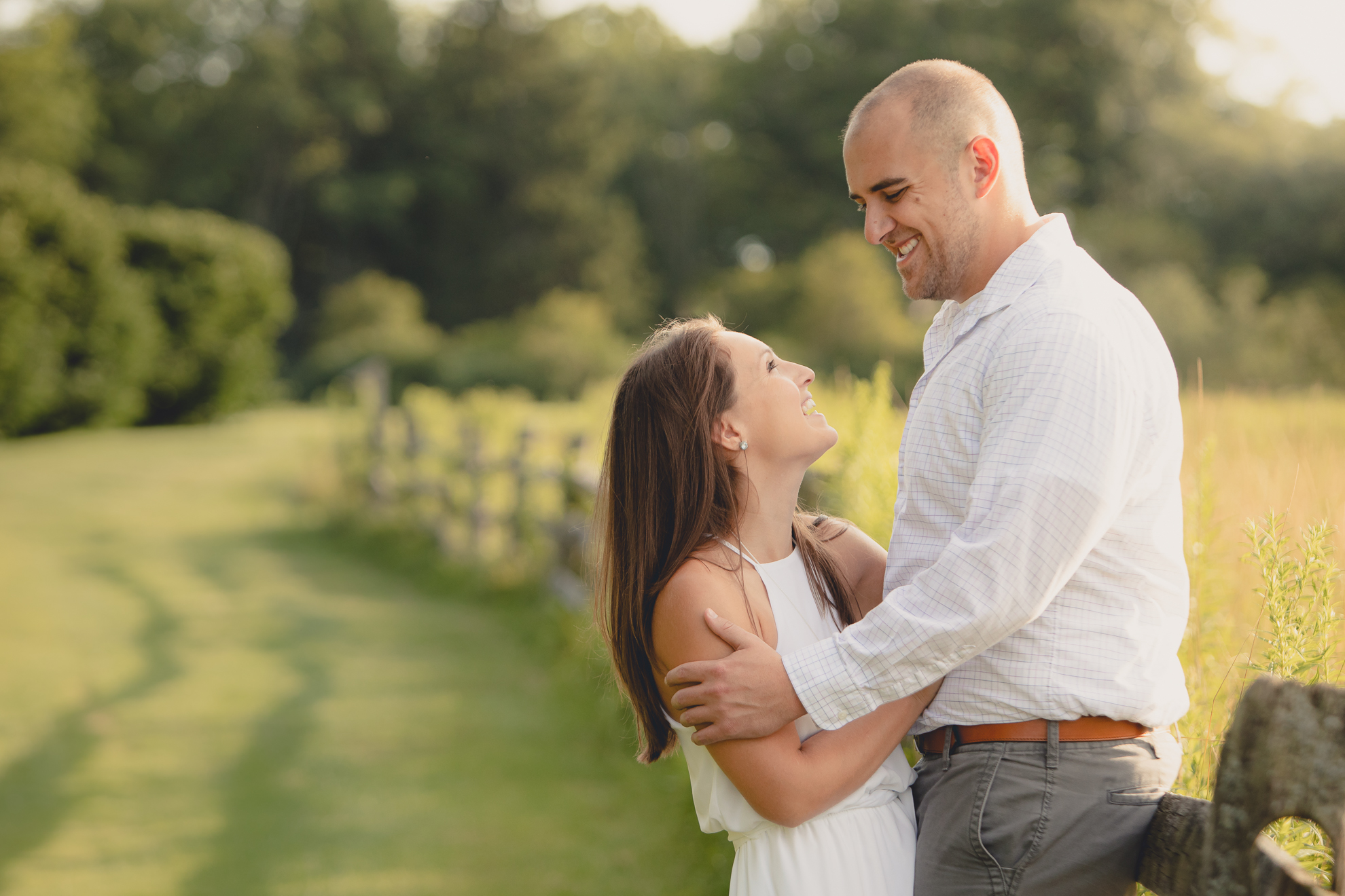 bride and groom laugh during wedding photography engagement portrait session in field at Knox Farm near Buffalo, NY