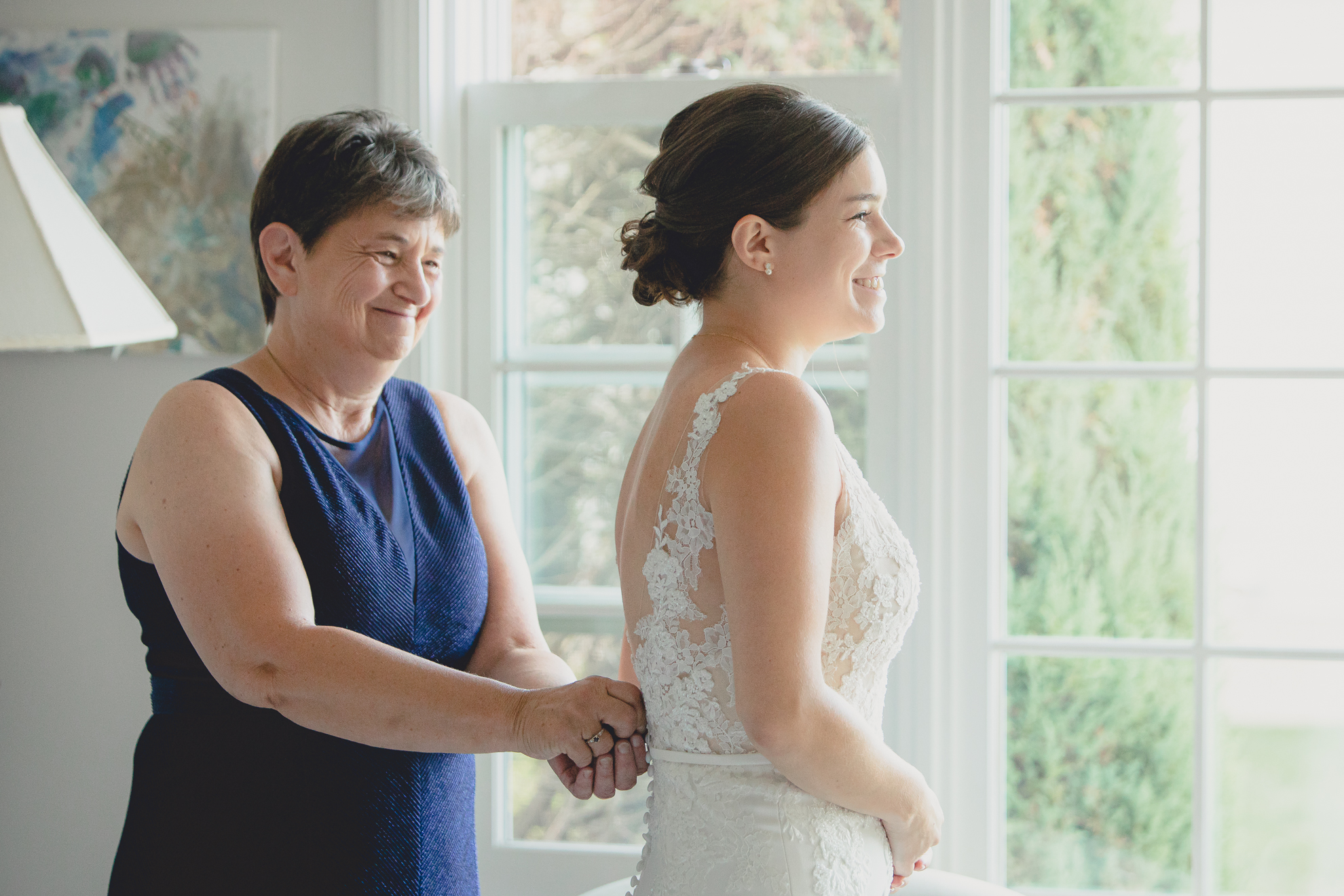 mom helps bride with wedding dress before micro wedding in WNY