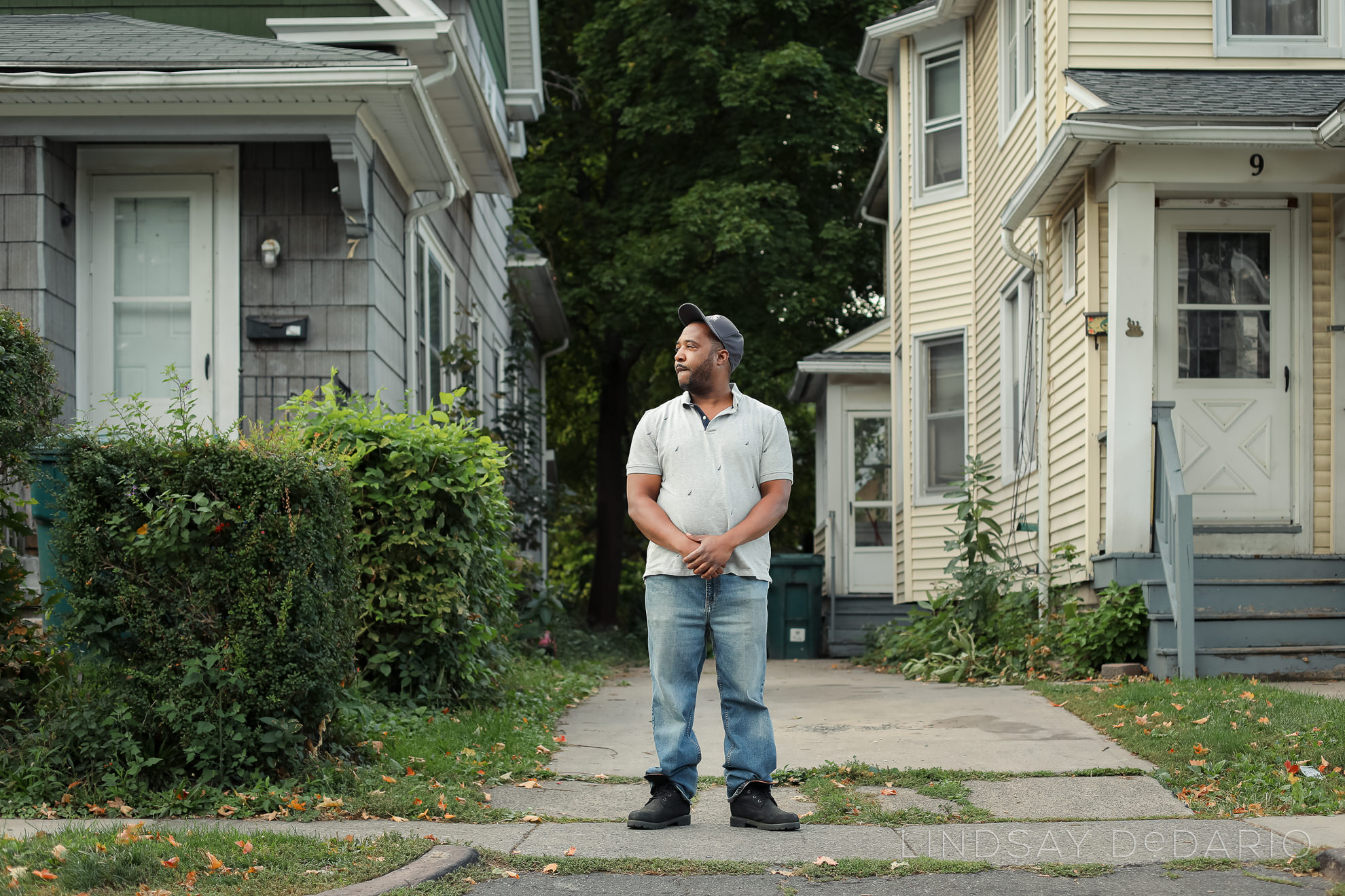 Silvon Simmons poses for portrait in front of driveway where he was shot by police in Rochester, NY