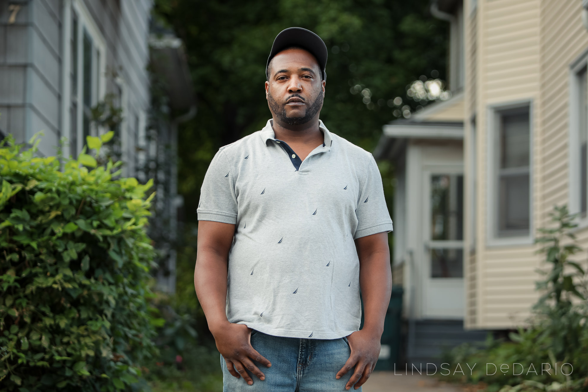 Silvon Simmons poses for portrait in front of driveway where he was shot by police in Rochester, NY