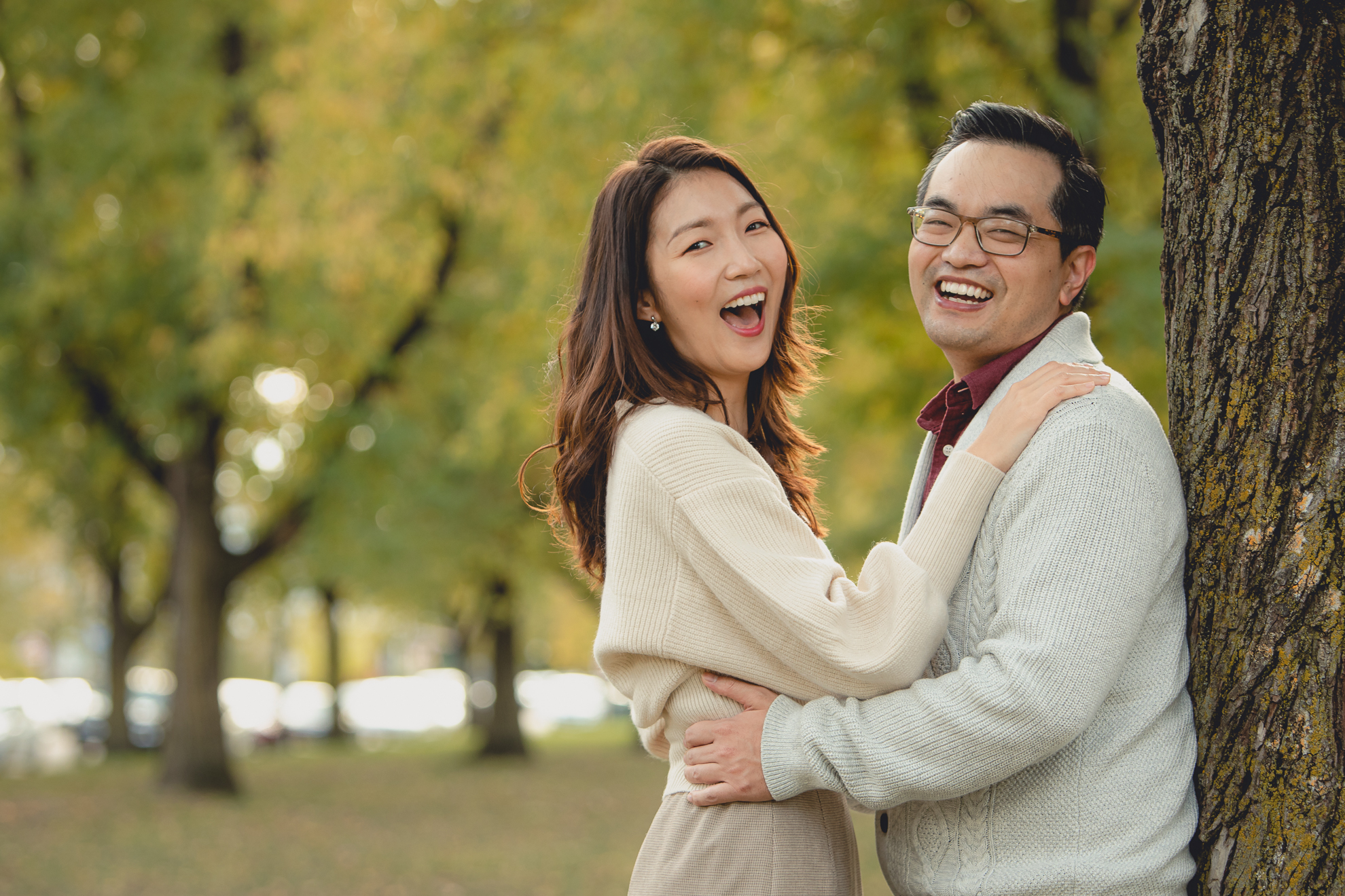 bride and groom laugh during engagement photos among fall foliage in Bidwell Parkway in Buffalo, NY