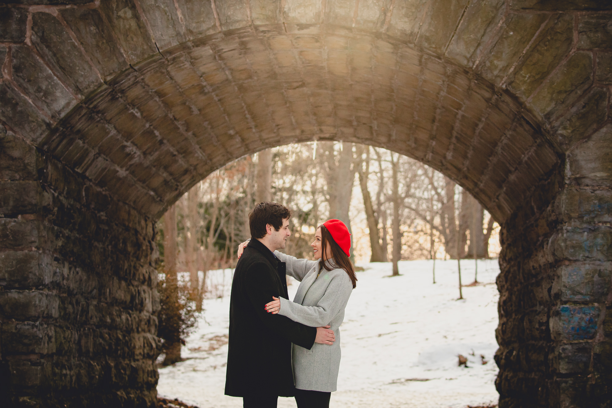 bride and groom smile at one another in front of the Ivy Bridge in Delaware Park during their wedding engagement photography session in Buffalo, NY