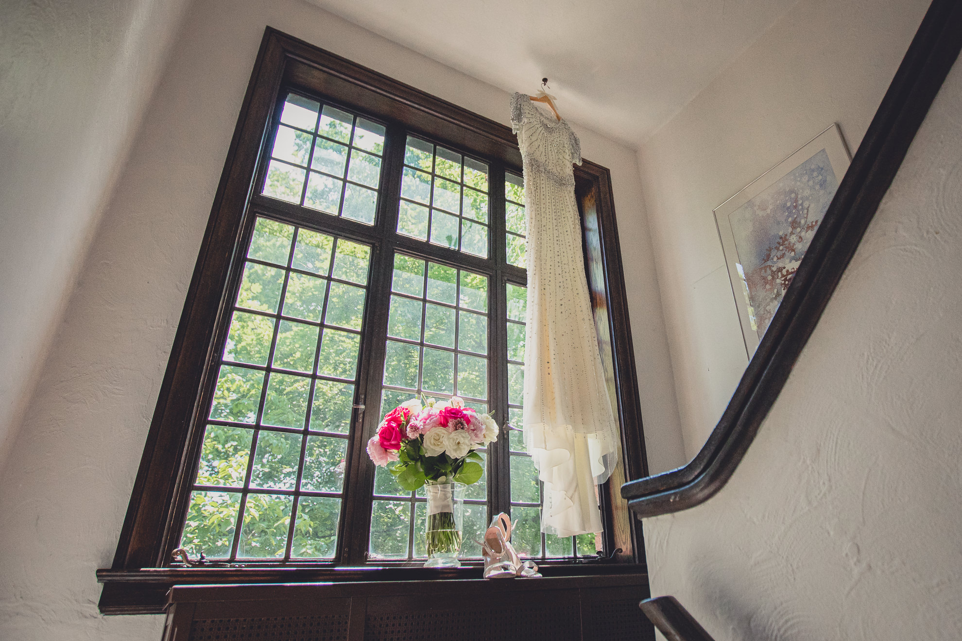 brides dress hangs in window before wedding in Lewiston, NY