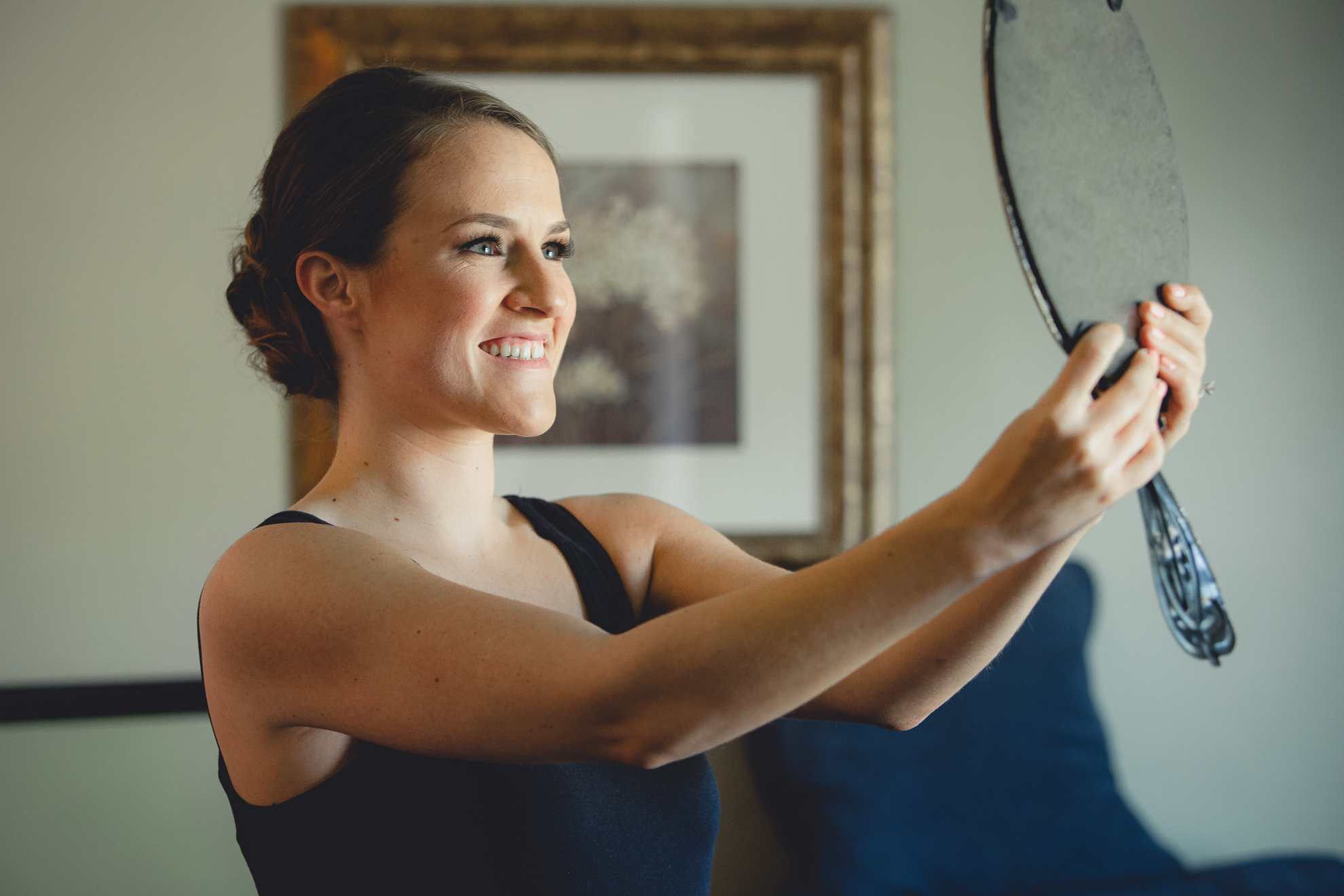 bride looks at self in mirror before wedding ceremony in Buffalo, NY