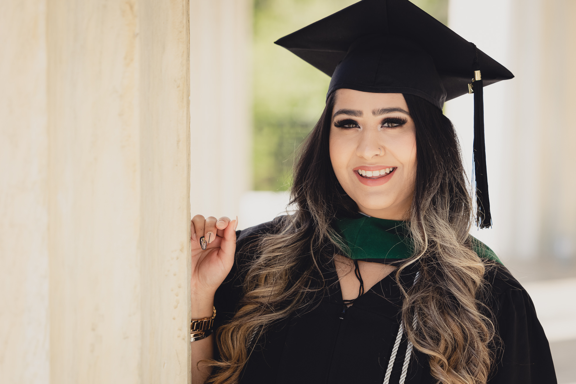 graduate smiles for photographer during senior graduation portrait photography at the History Museum in Buffalo, NY