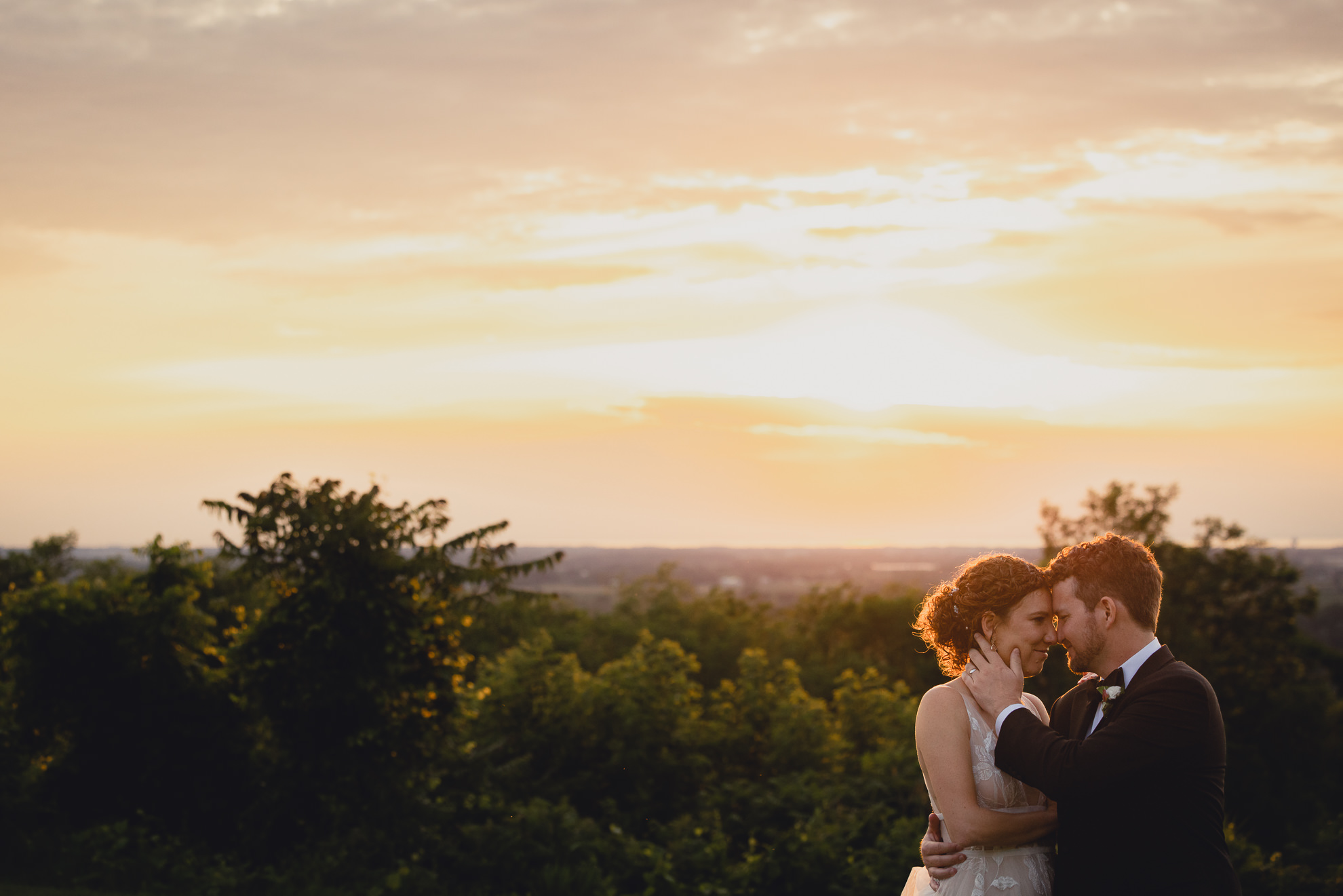 bride and groom walk through lawn at sunset during wedding reception at the Niagara Falls Country Club