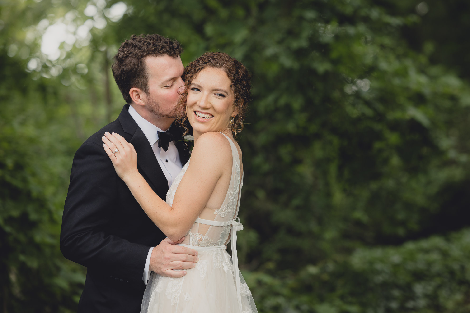 groom kisses bride on cheek at Barton Hill House in Lewiston, NY before wedding