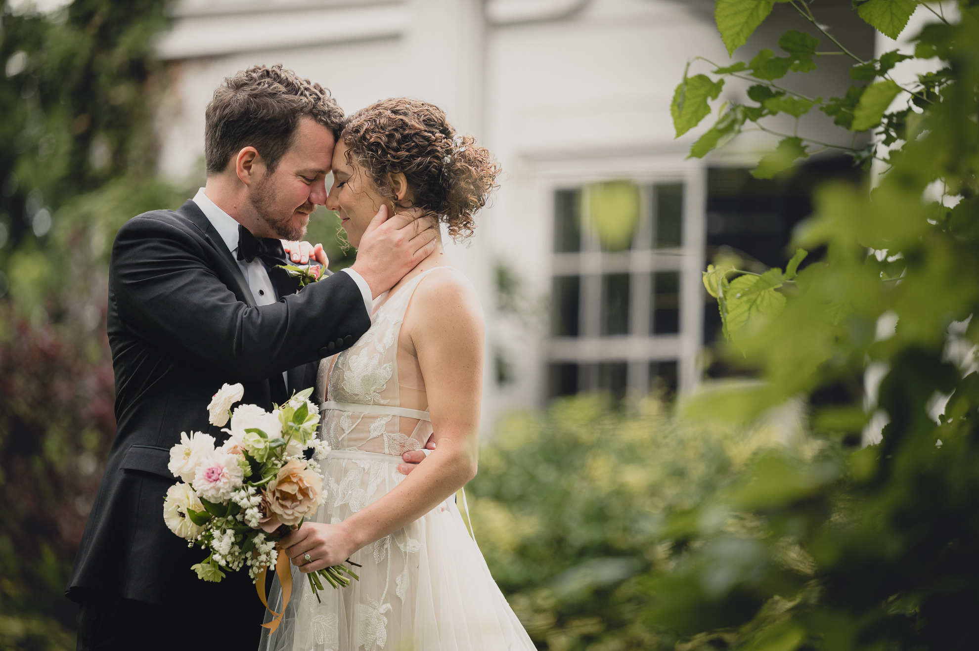 groom and bride embrace at Barton Hill House in Lewiston, NY before wedding