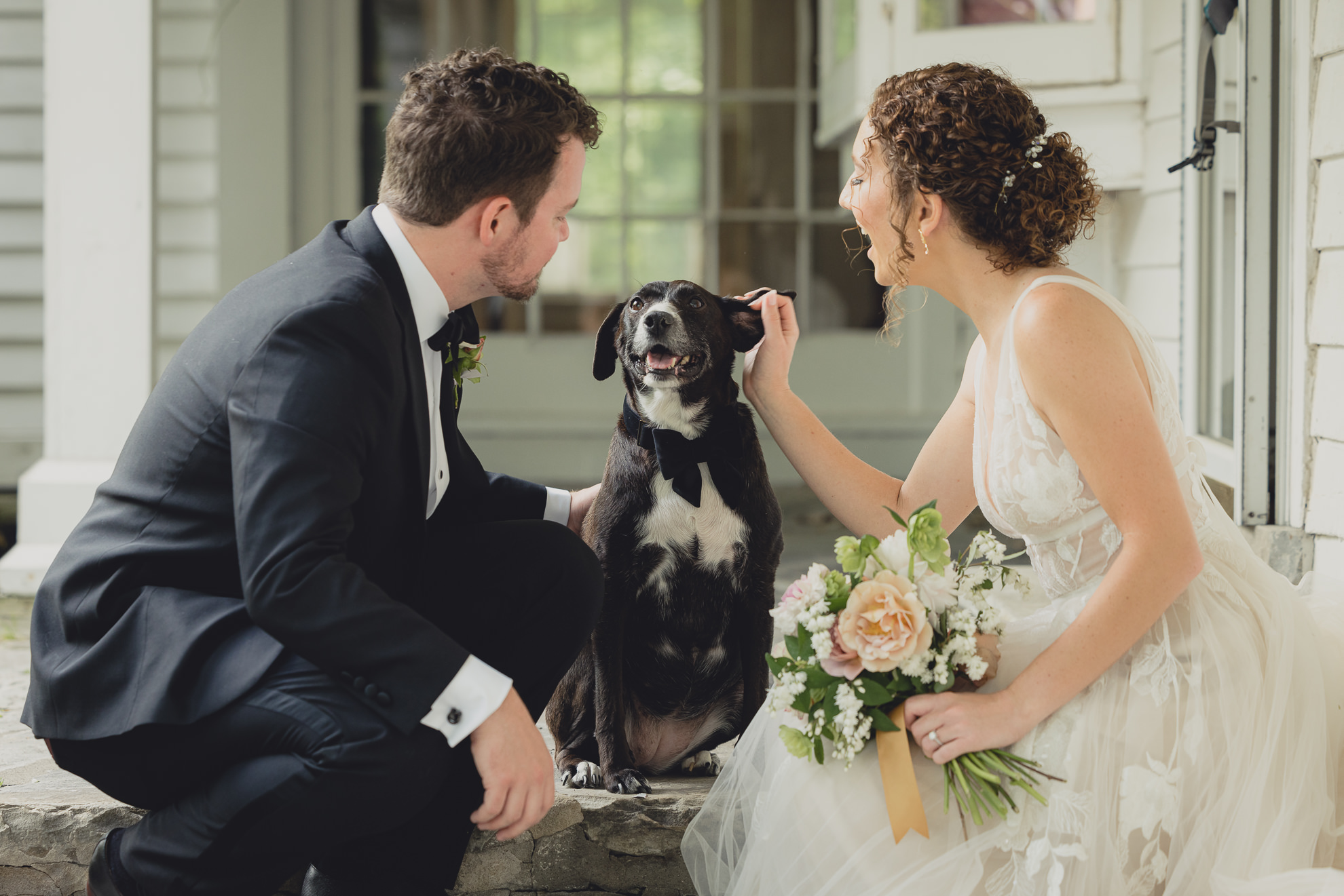 bride and groom play with dog at Barton Hill House in Lewiston, NY before wedding