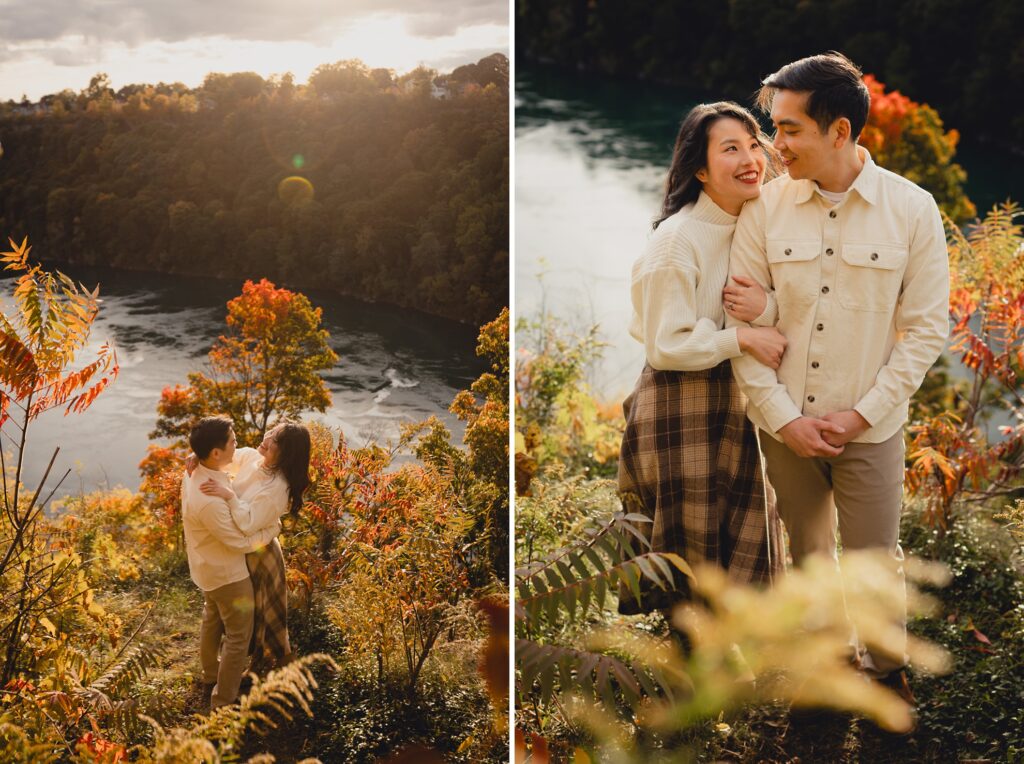 couple embraces with Niagara River and fall foliage behind them during engagement session in Niagara Falls, NY