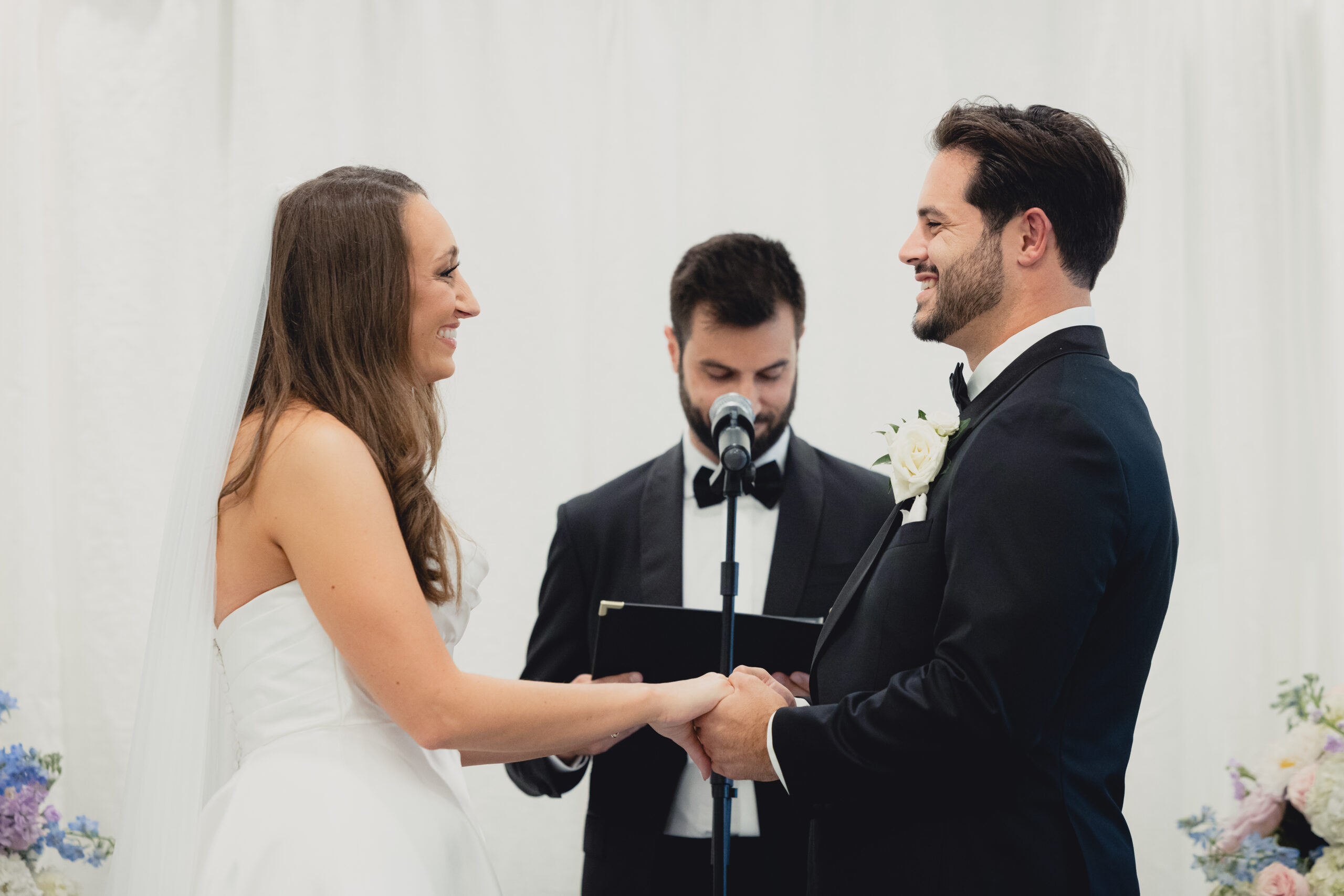 bride and groom smile at each other during wedding ceremony in the Portico Gallery of the Buffalo History Museum
