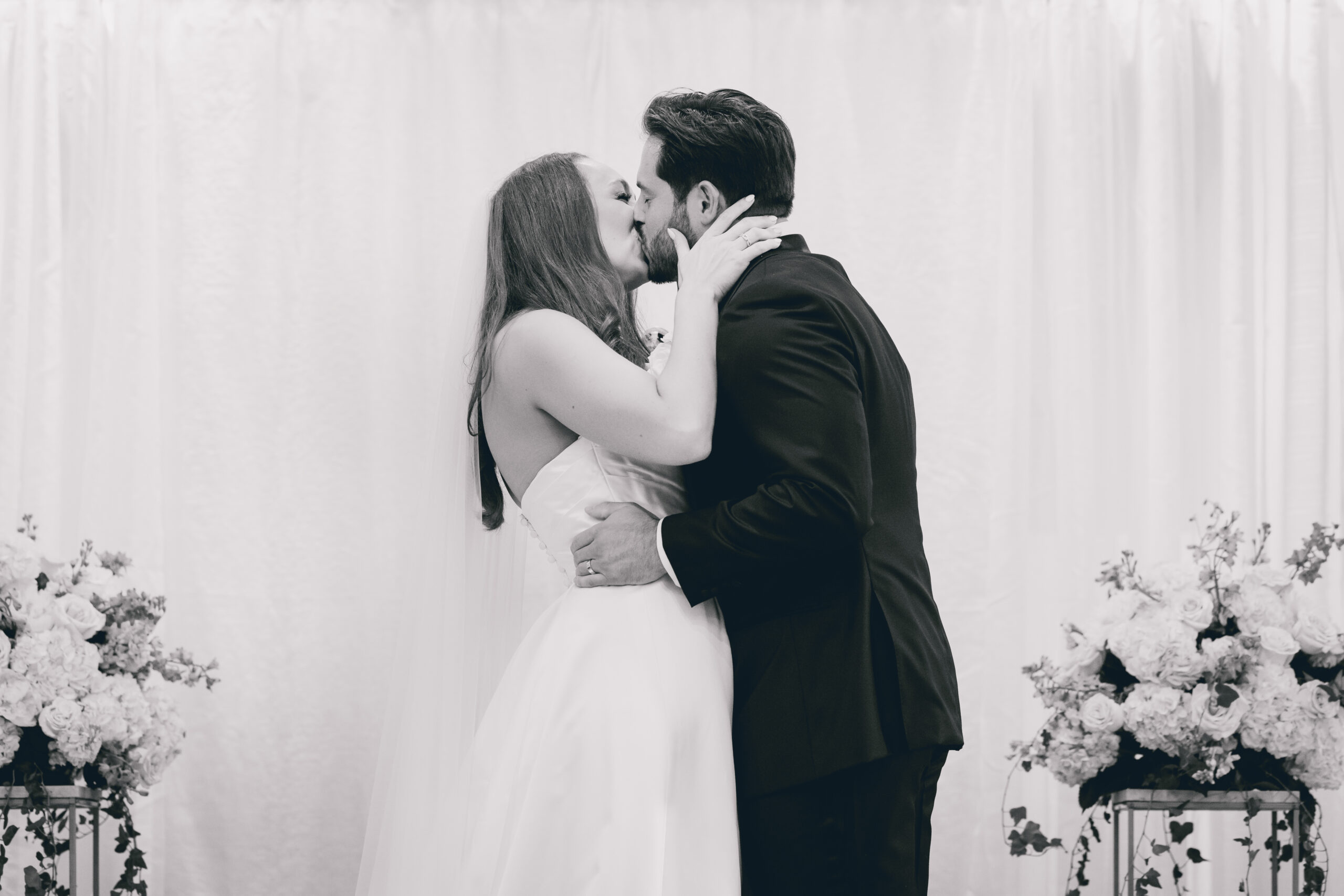couple kisses after wedding ceremony in the Portico Gallery of the Buffalo History Museum