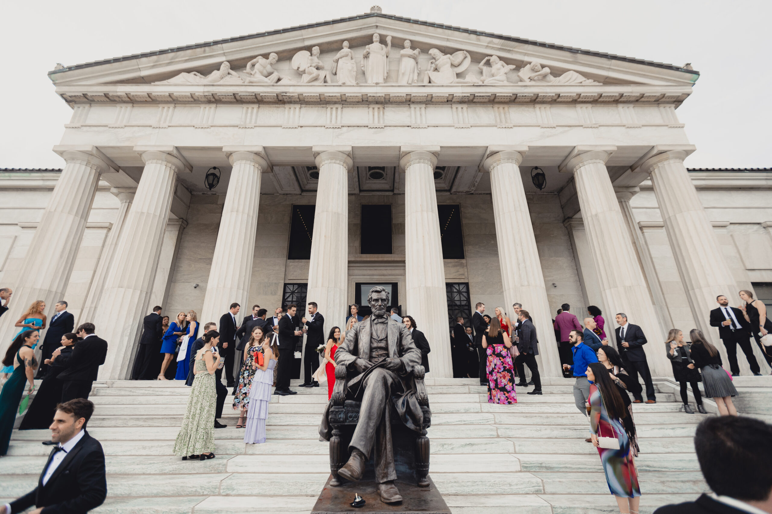 guests enjoy cocktail hour on portico during wedding reception at the Buffalo History Museum
