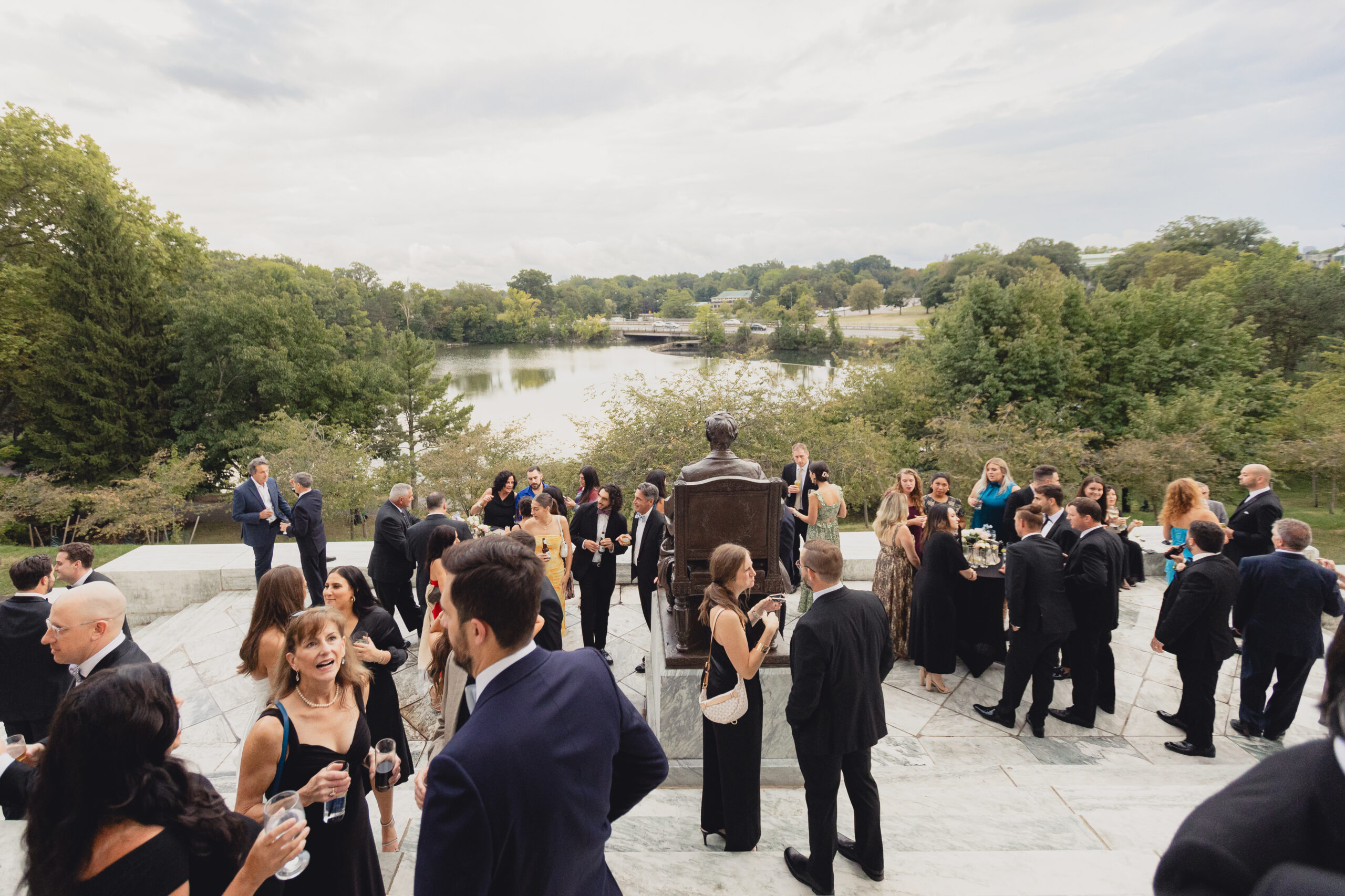 guests enjoy cocktail hour on portico during wedding reception at the Buffalo History Museum