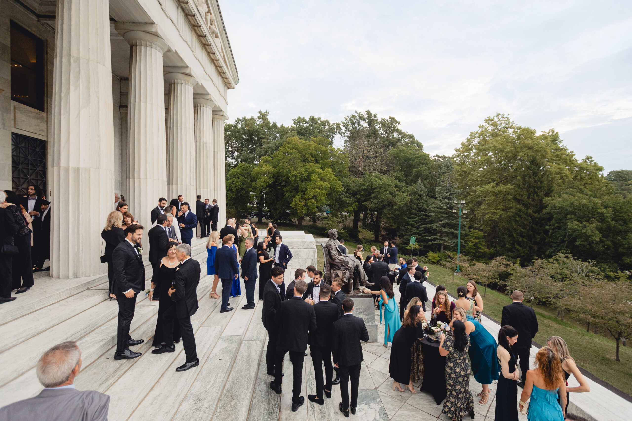 guests enjoy cocktail hour on portico during wedding reception at the Buffalo History Museum