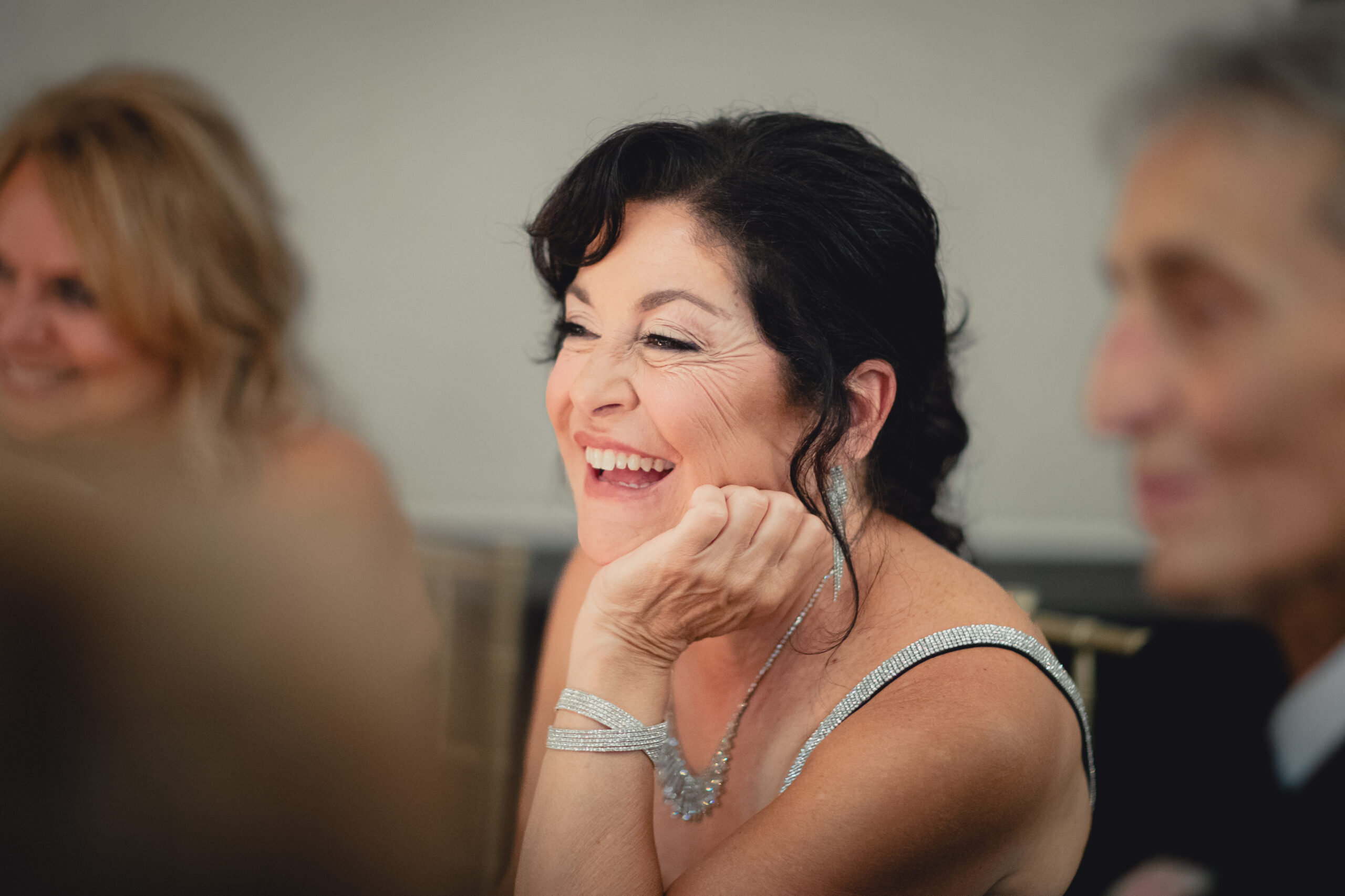 mother of groom laughs during speeches during wedding reception at the Buffalo History Museum