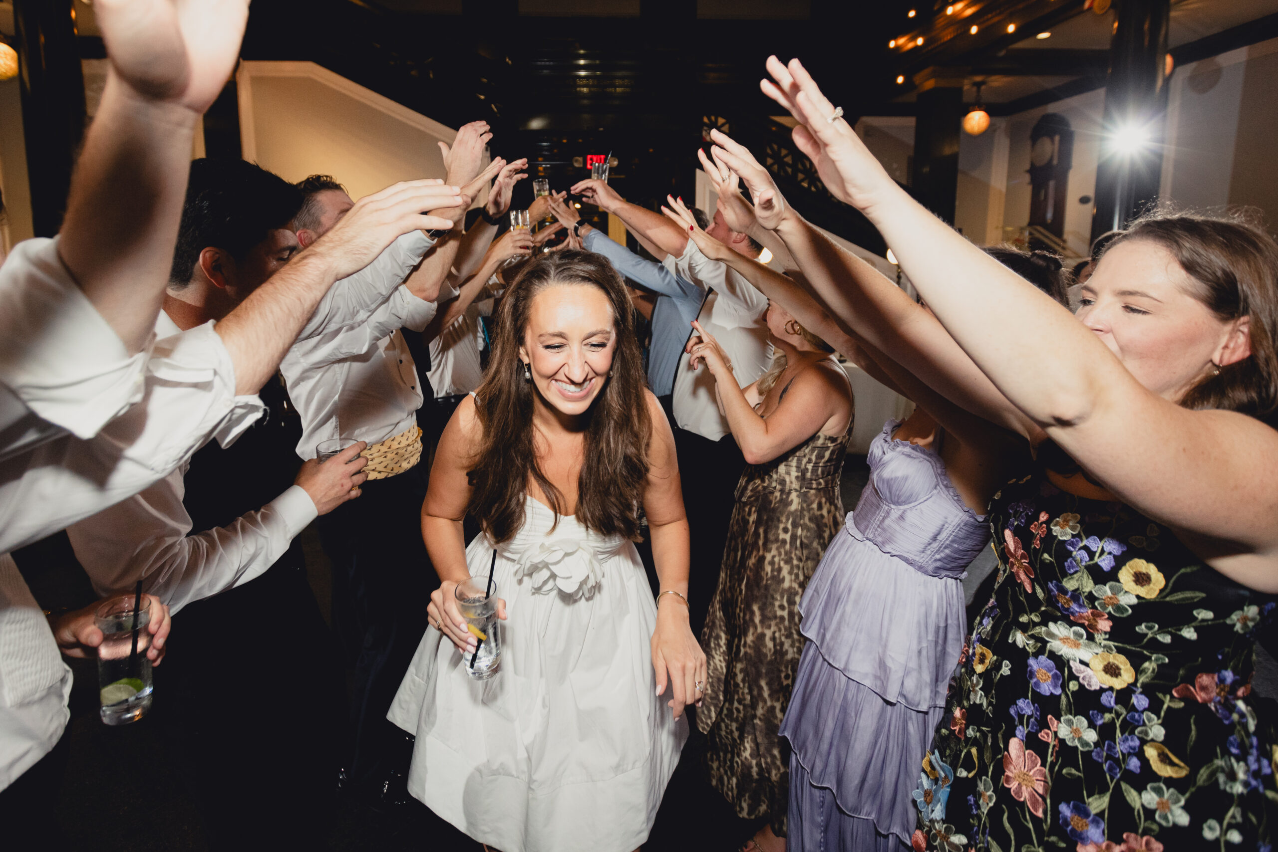 bride dances under outstretched guest arms during wedding reception at the Buffalo History Museum