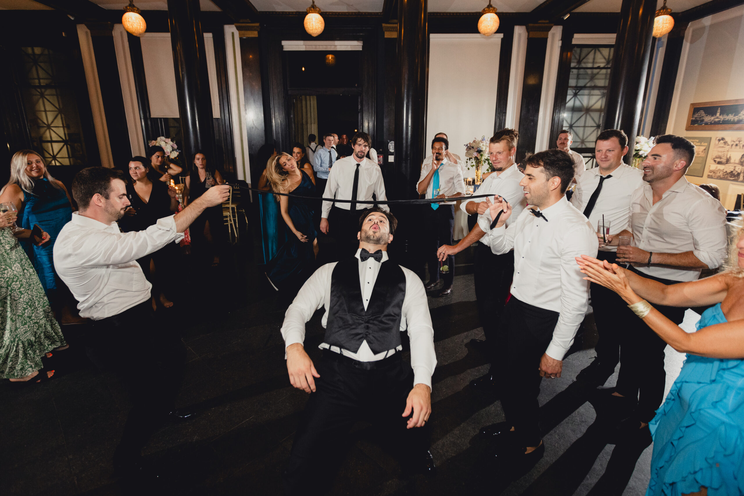 groom limbos during wedding reception at the Buffalo History Museum