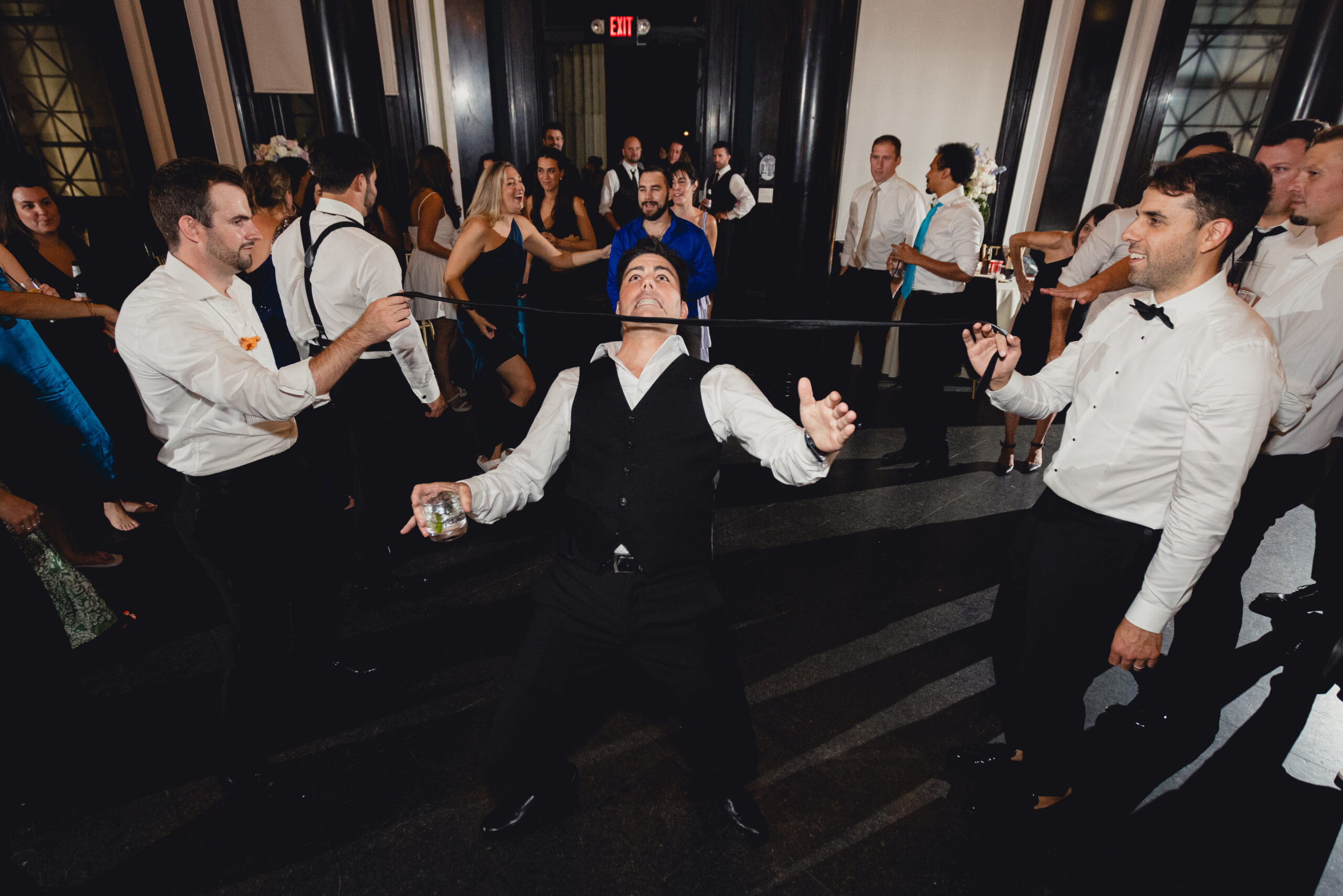 groomsman limbos during wedding reception at the Buffalo History Museum