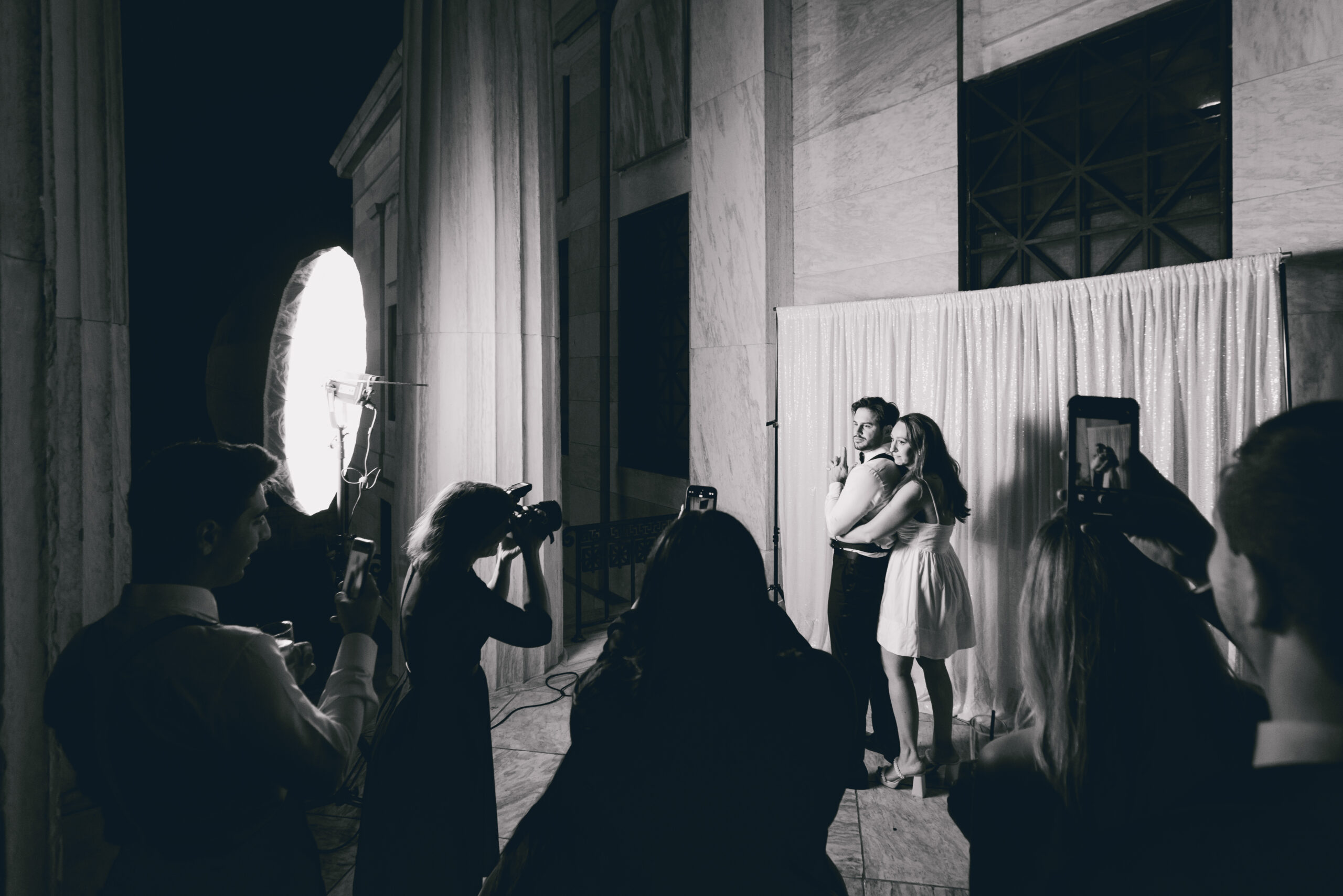 bride and groom pose in portrait station booth on portico during wedding reception at the Buffalo History Museum