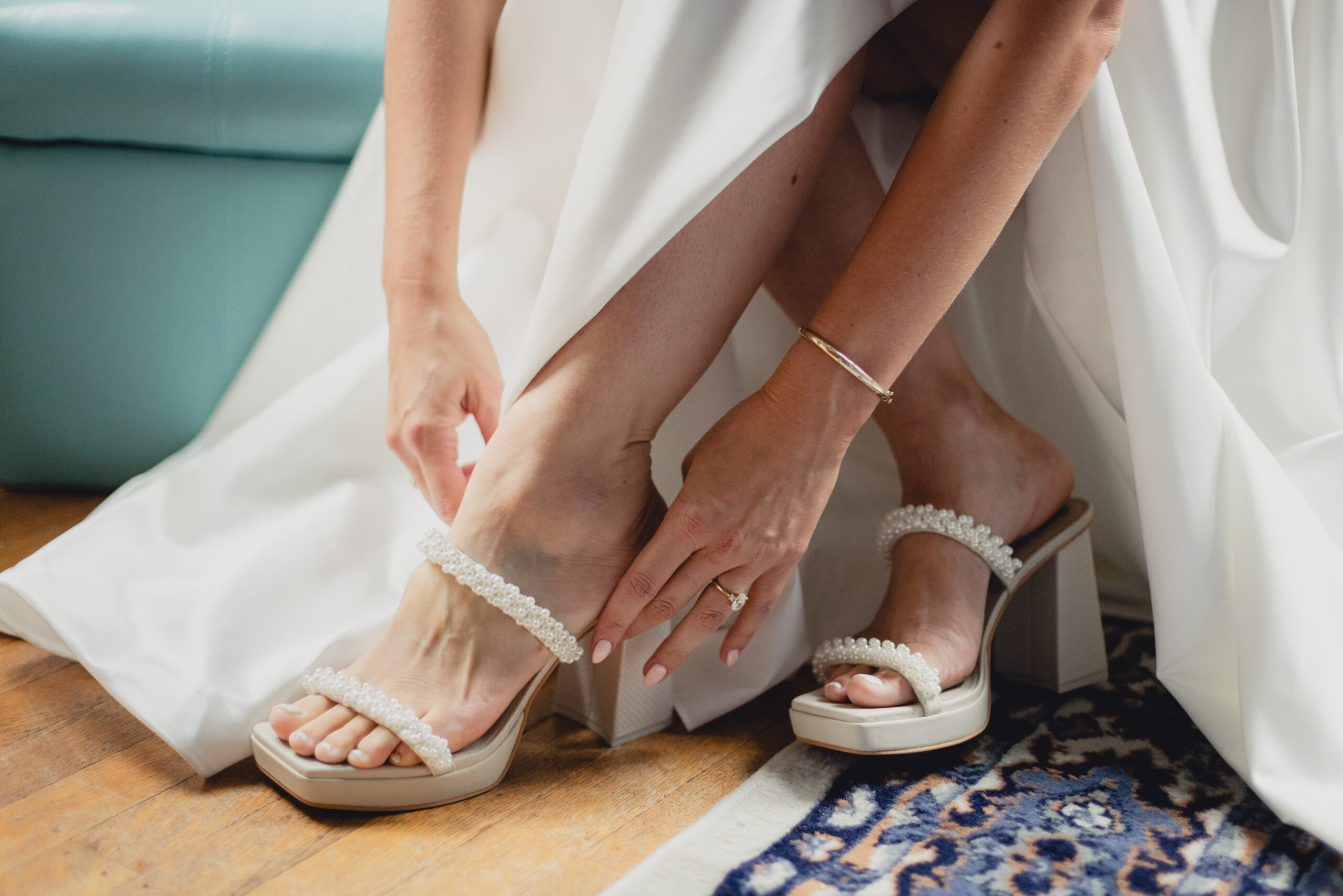 bride puts on shoes in childhood bedroom before wedding in Buffalo, NY