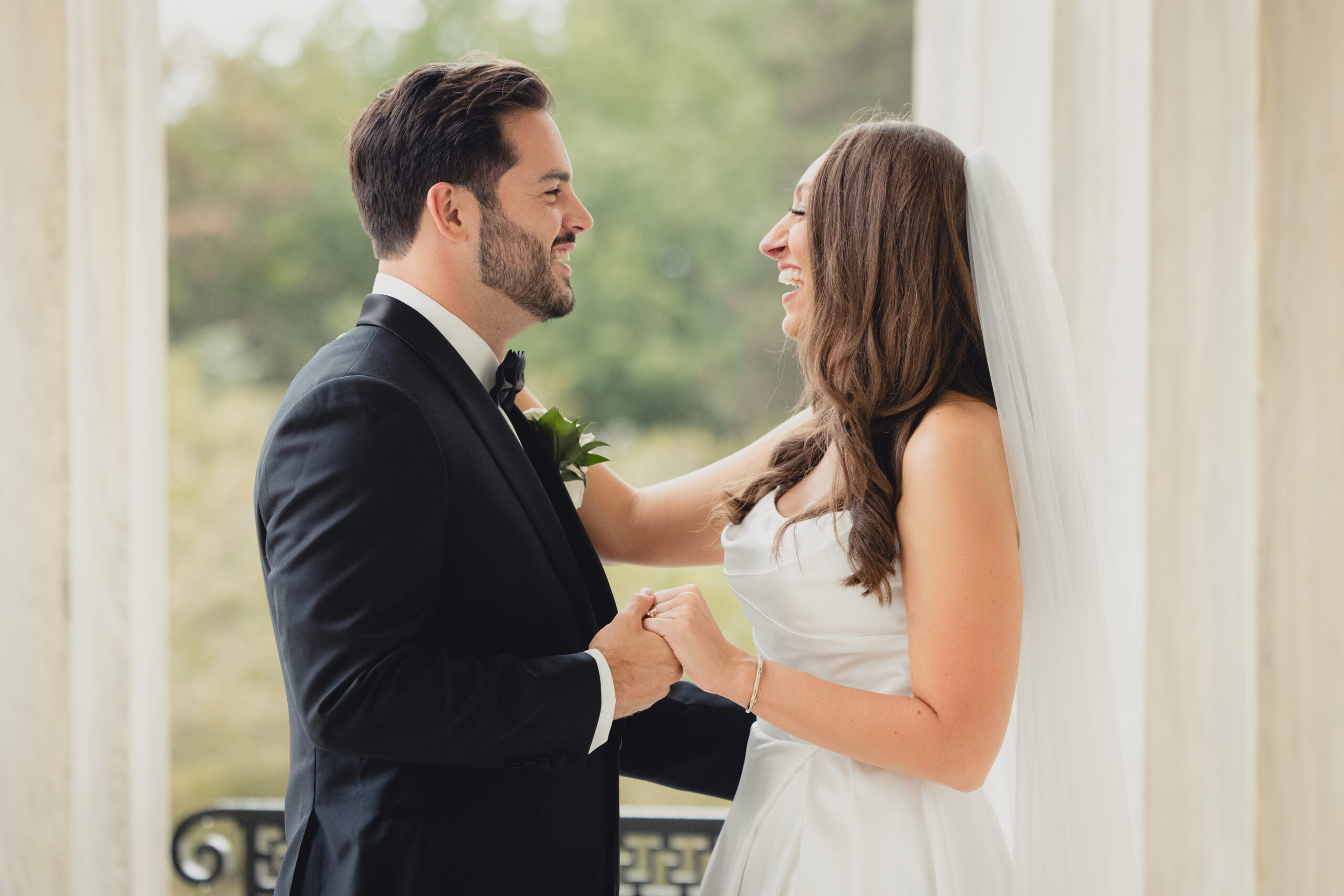 bride and groom pose for portraits on portico of the Buffalo History Museum on wedding day
