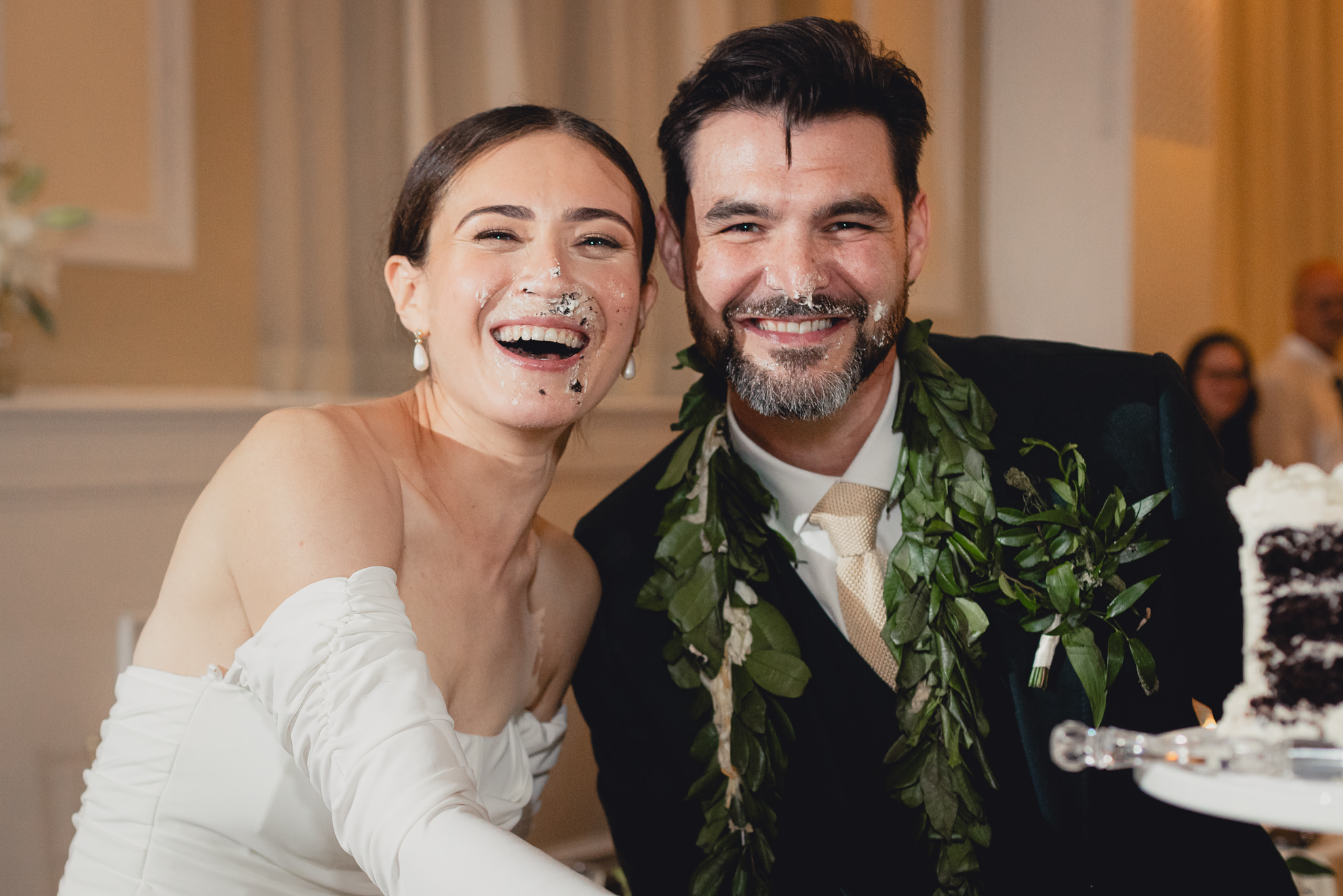 bride and groom shove cake all over each others faces during wedding reception at the Hotel Lafayette in Buffalo, NY