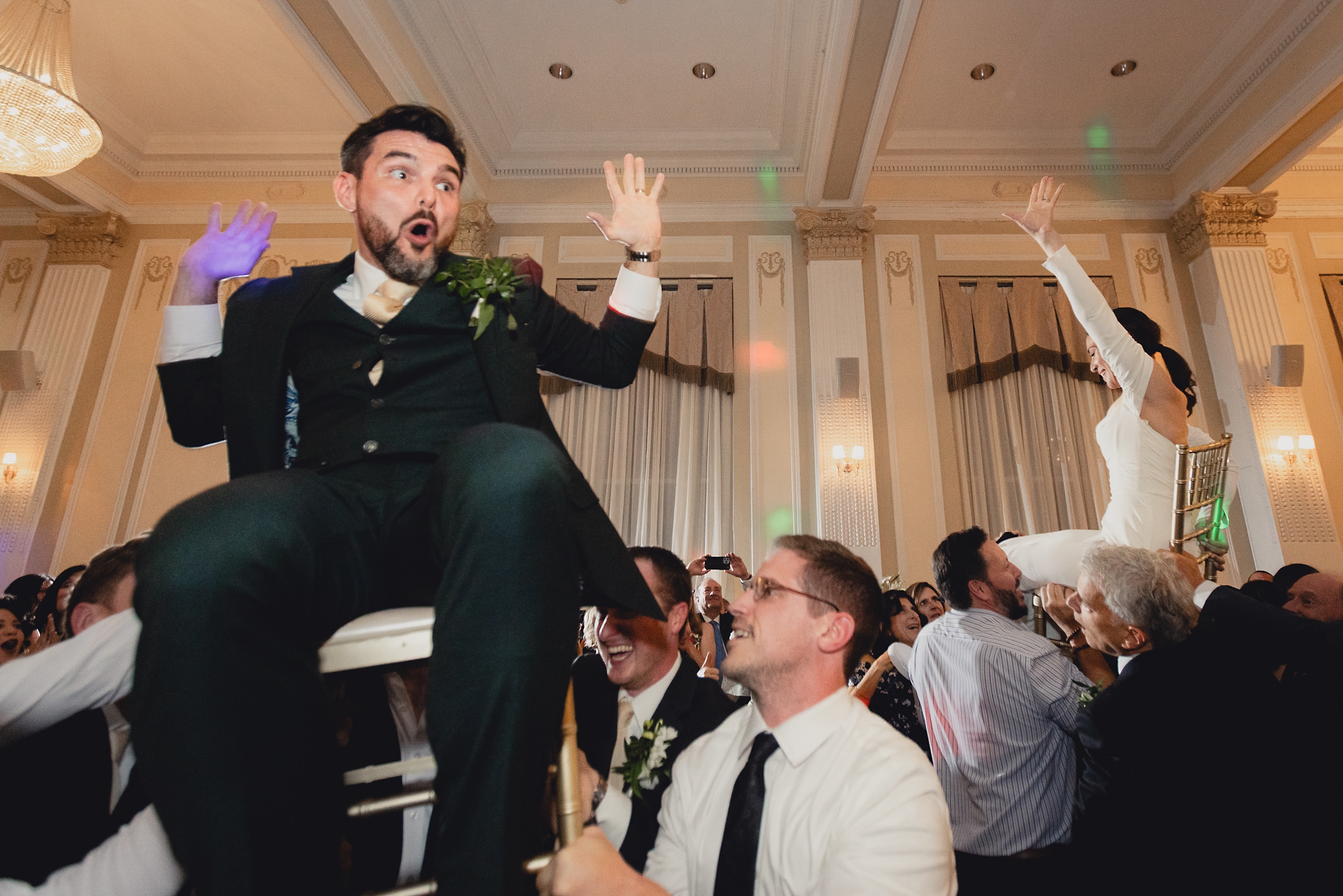 bride and groom lifted on chairs during hava nagila during wedding reception at the Hotel Lafayette in Buffalo, NY
