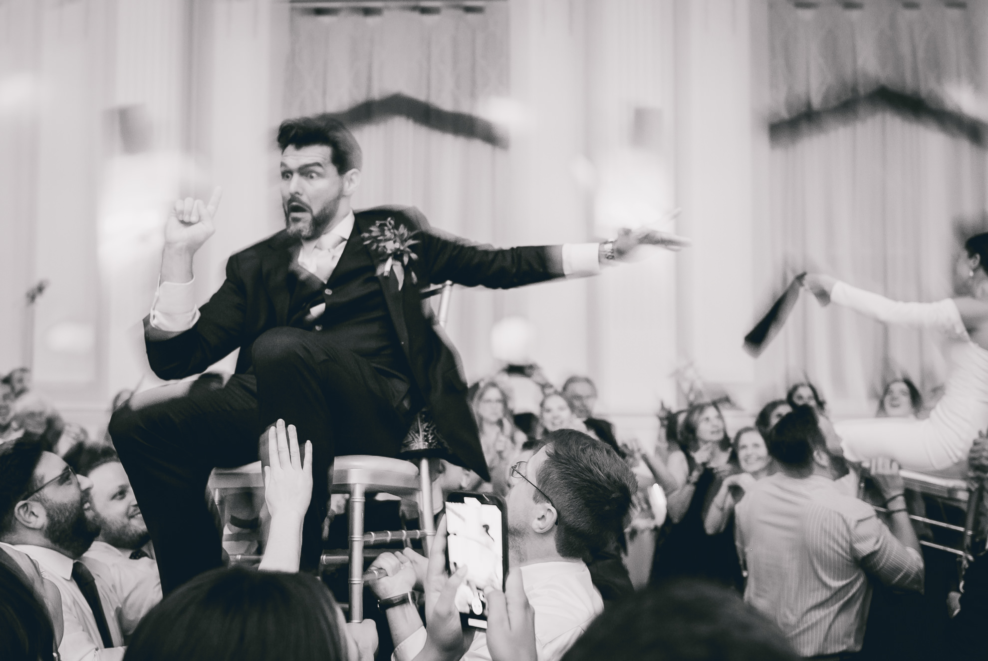 bride and groom lifted on chairs during hava nagila during wedding reception at the Hotel Lafayette in Buffalo, NY
