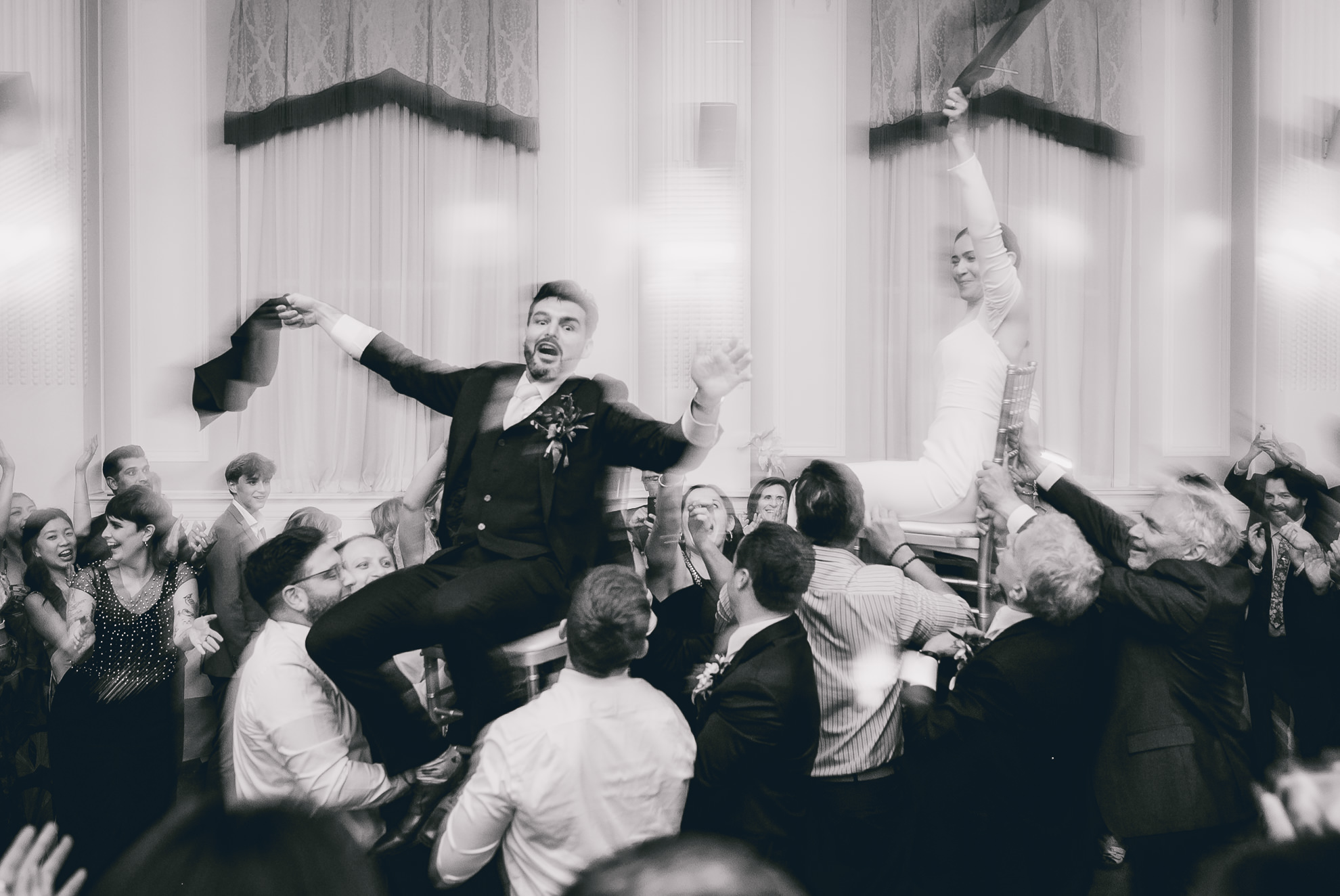 bride and groom lifted on chairs during hava nagila during wedding reception at the Hotel Lafayette in Buffalo, NY