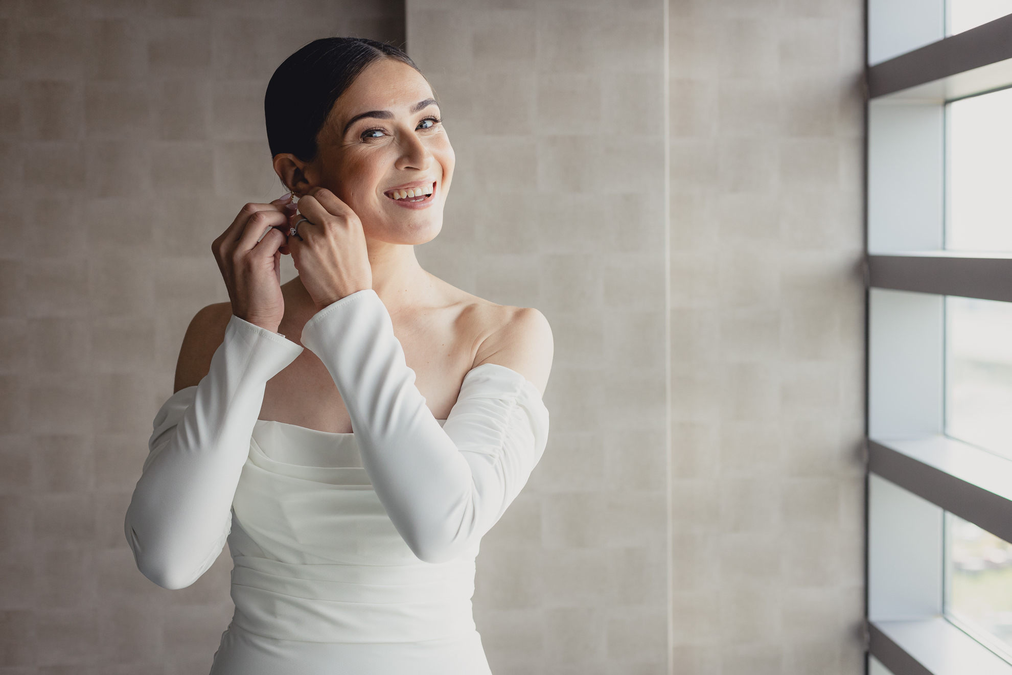 bride puts in earrings at Marriott Lecom Harborcenter