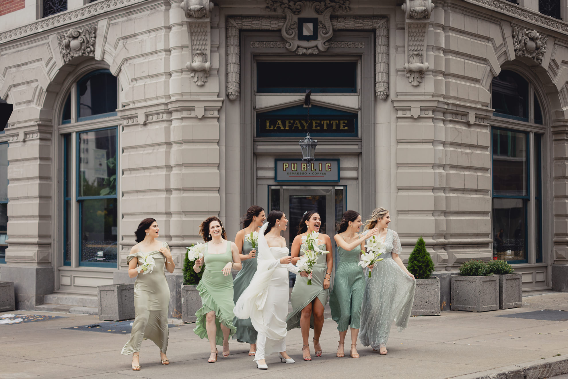 bridesmaids cross street in downtown Buffalo before wedding